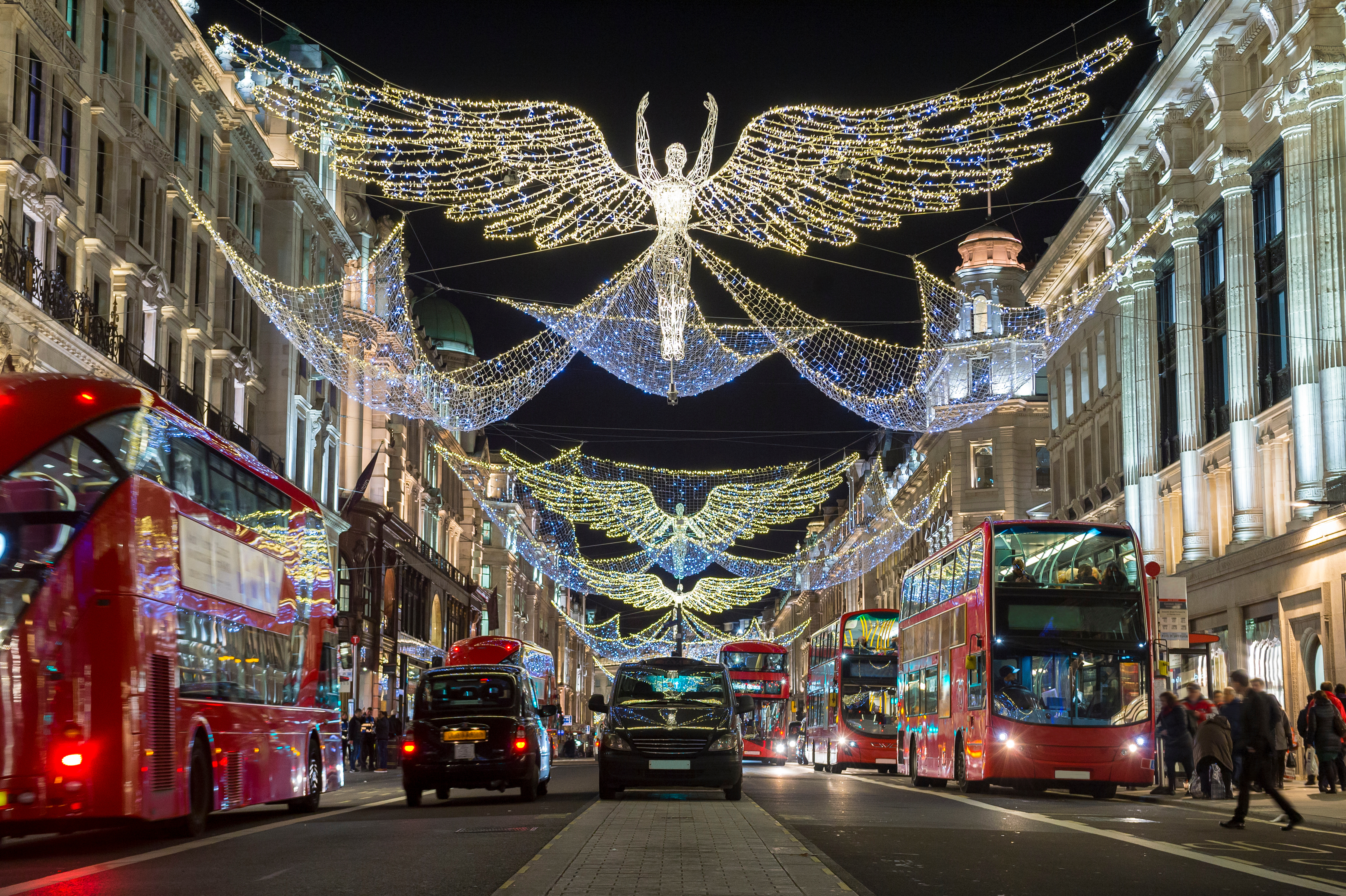 Festlige julelys med glødende engle over Regent Street i London på en mørk vinternat
