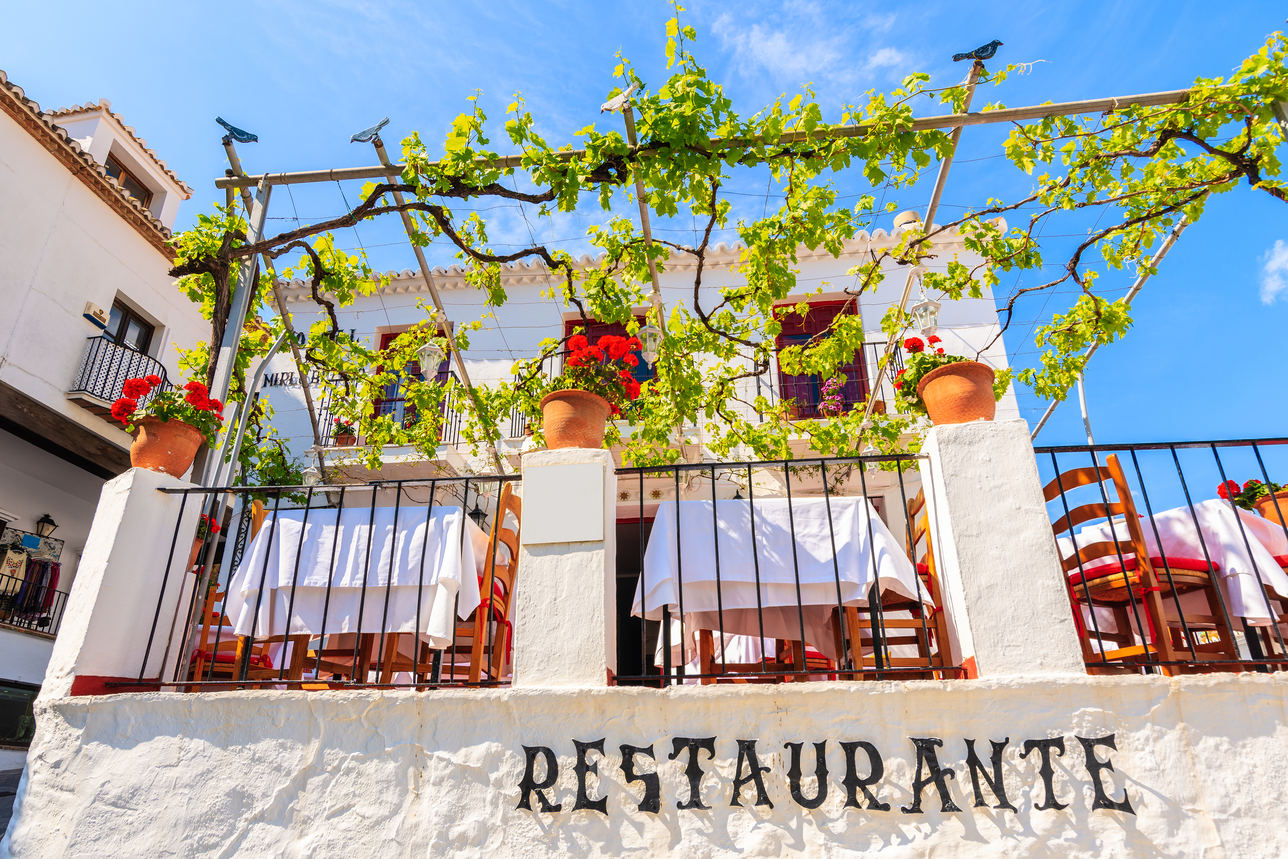 Hyggelig udendørs restaurant i den fascinerende hvide landsby Mijas i Andalusien, hvor man kan nyde et måltid på terrassen mellem de traditionelle hvidkalkede bygninger