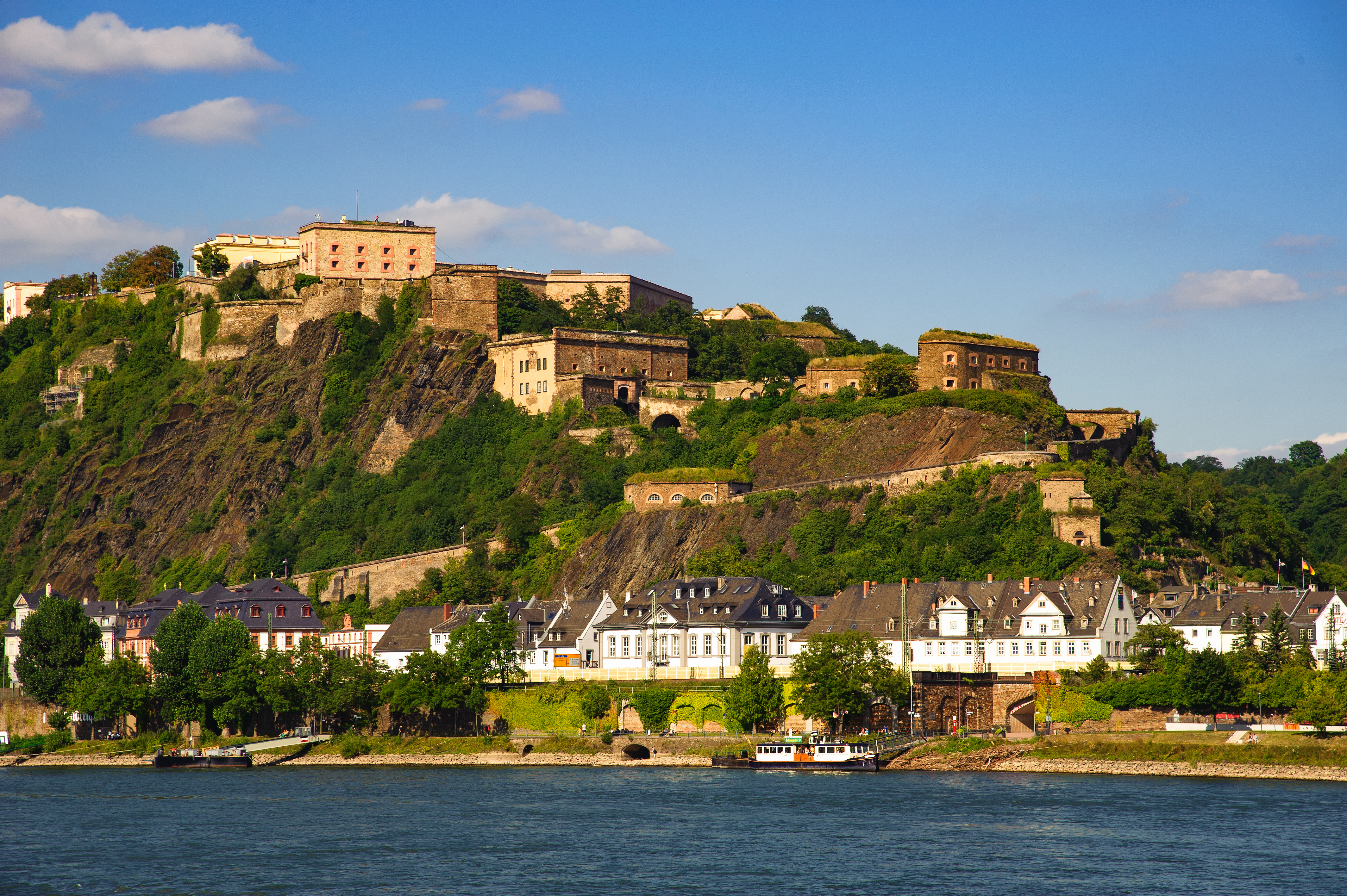 Ehrenbreitstein-fæstningen, en berømt historisk seværdighed i Koblenz ved Rhinens bred med frodig natur og blå himmel