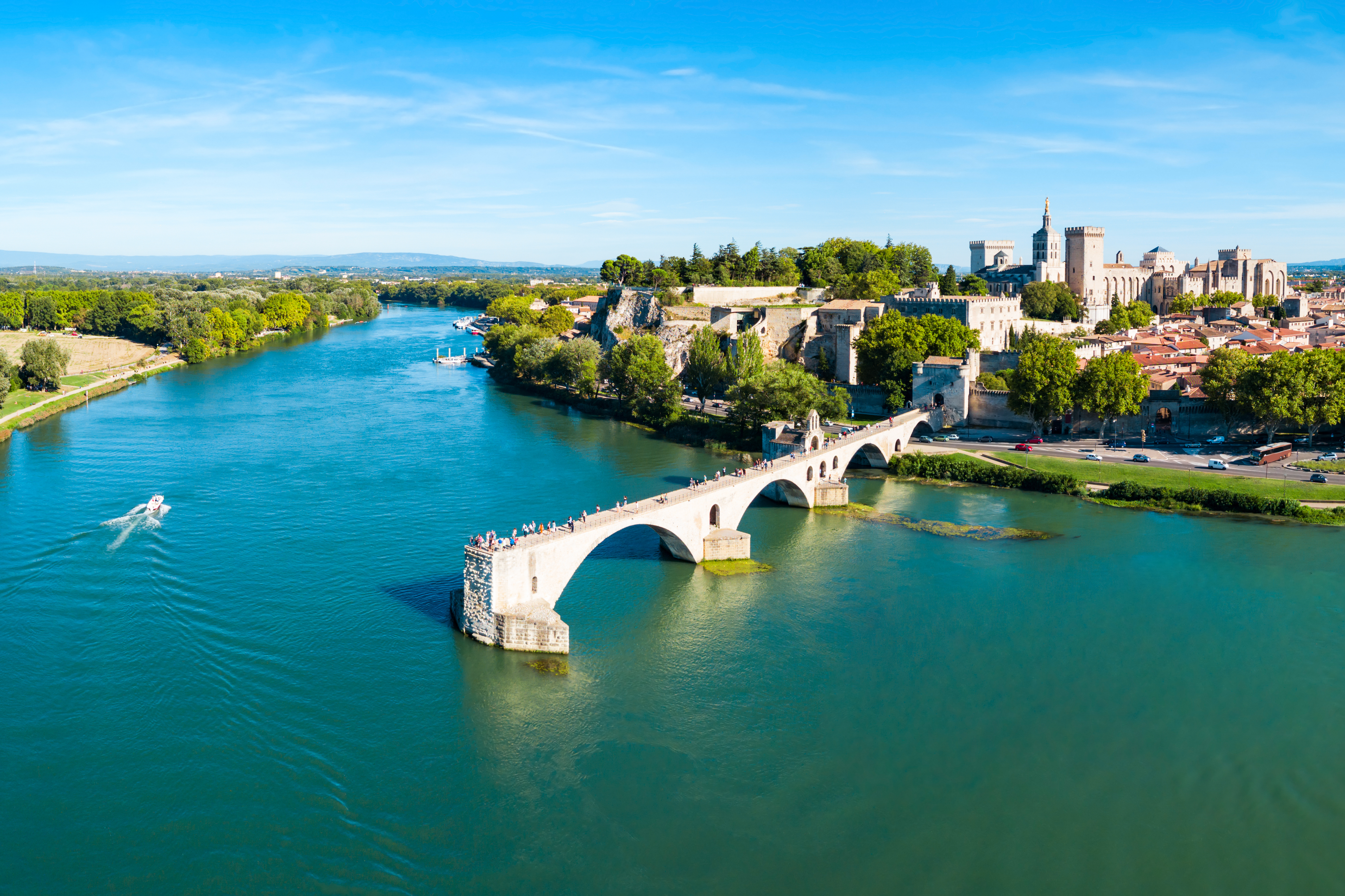 Betagende luftudsigt over Pont Saint-Benezet broen og Rhône-floden i Avignon med den charmerende gamle by og det majestætiske Pavepalads under klar himmel