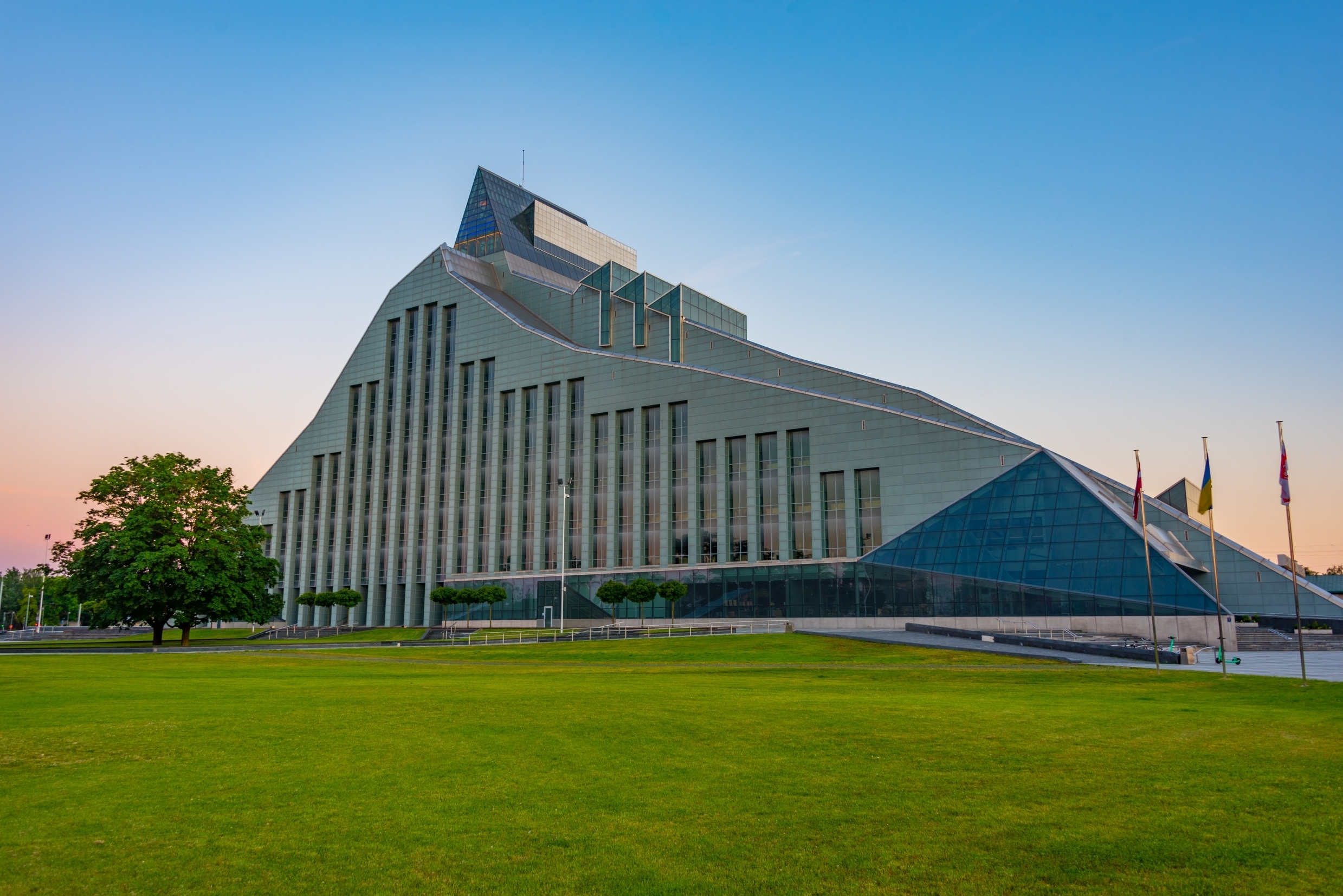 Det moderne Lettiske Nationalbibliotek i Riga med sin spektakulære glasarkitektur og grønne omgivelser ved solnedgang