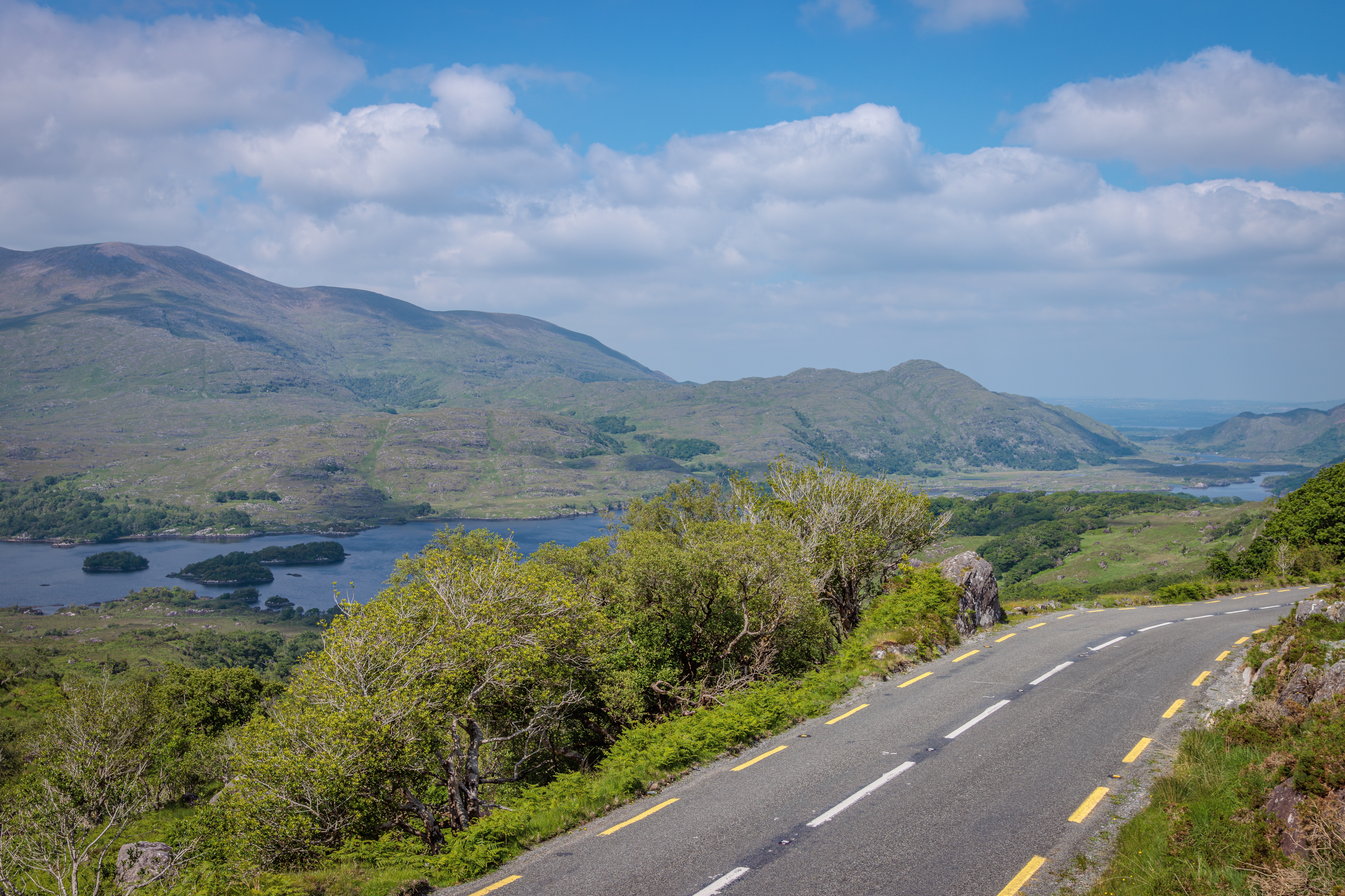 Storslået irsk landskab ved Ring of Kerry med snoet vej og udsigt over Killarney-søerne og grønne bjerge