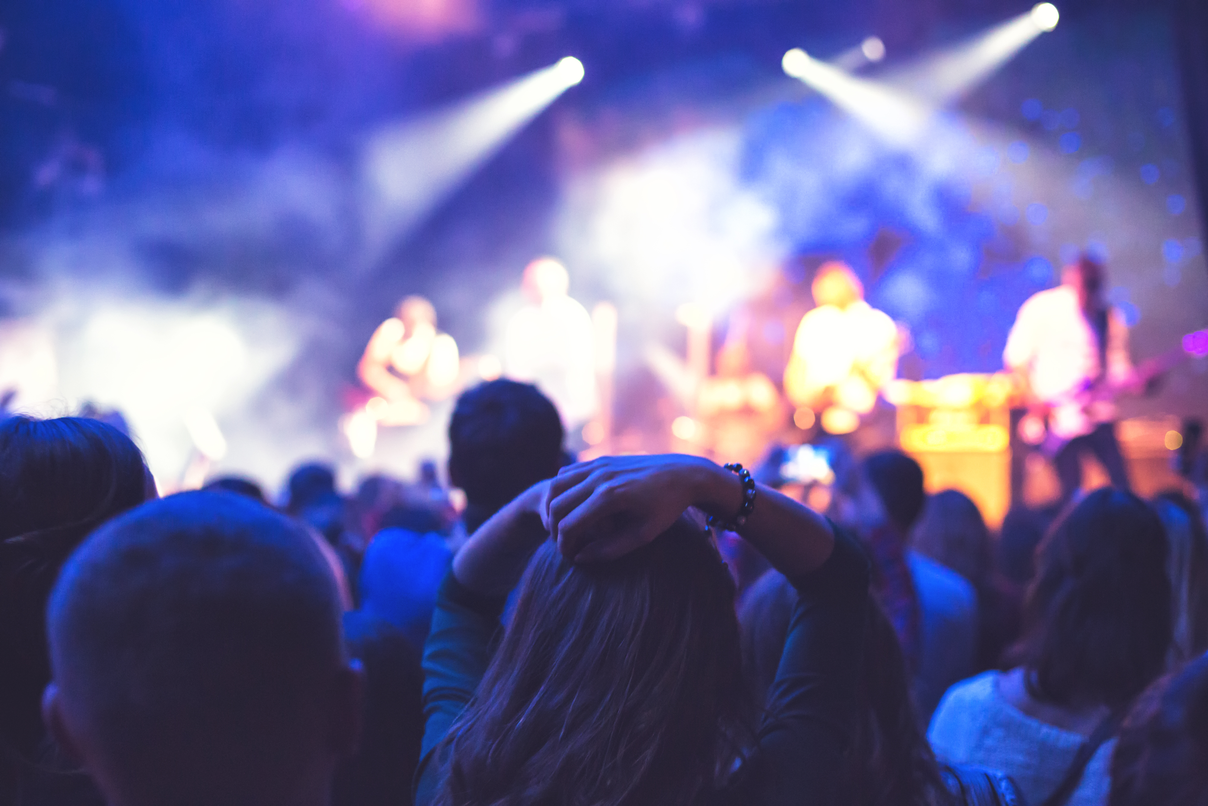 Rock koncert med dramatiske scenelys og engageret publikum