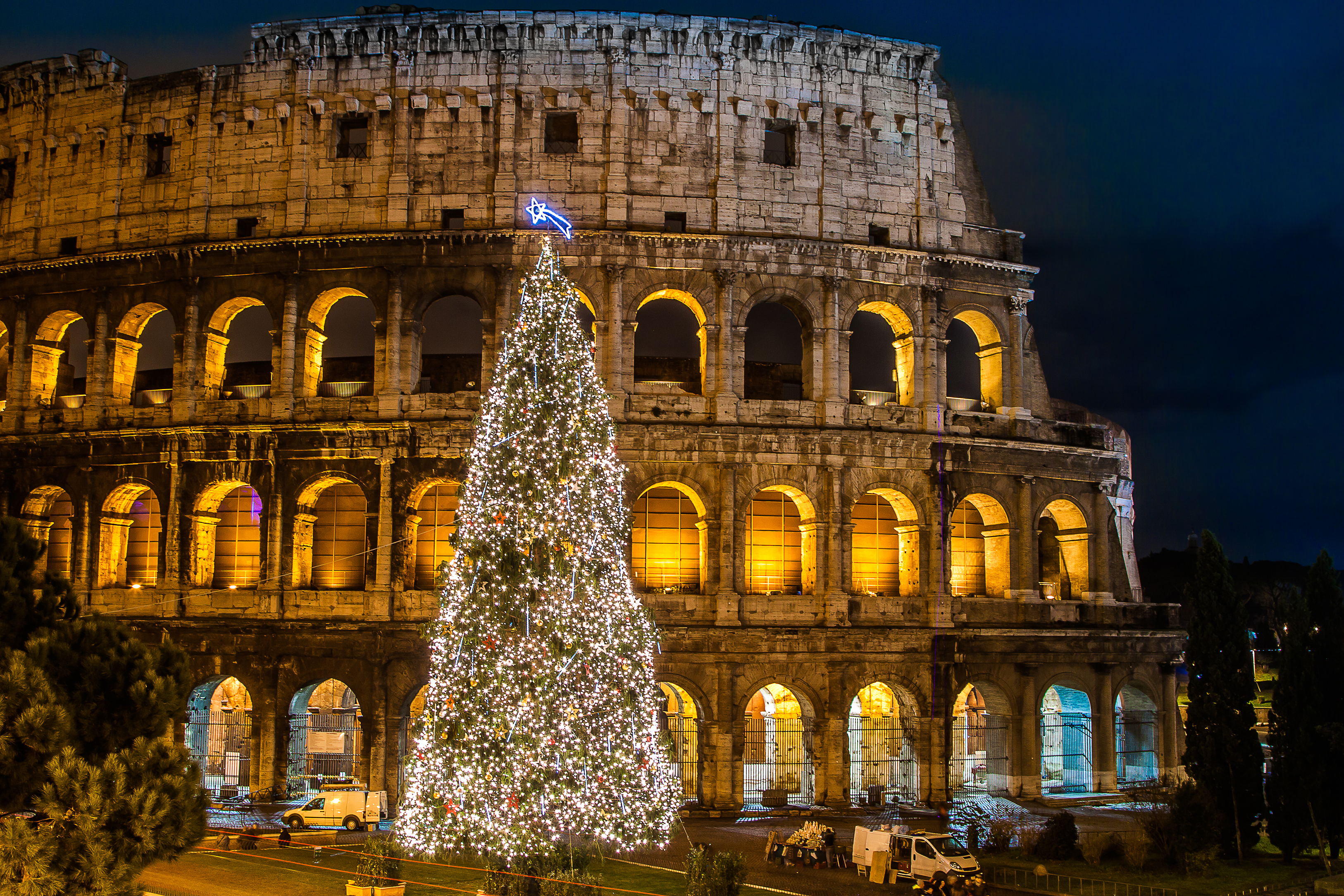 Colosseum i Rom smukt oplyst om aftenen med stort juletræ til jul