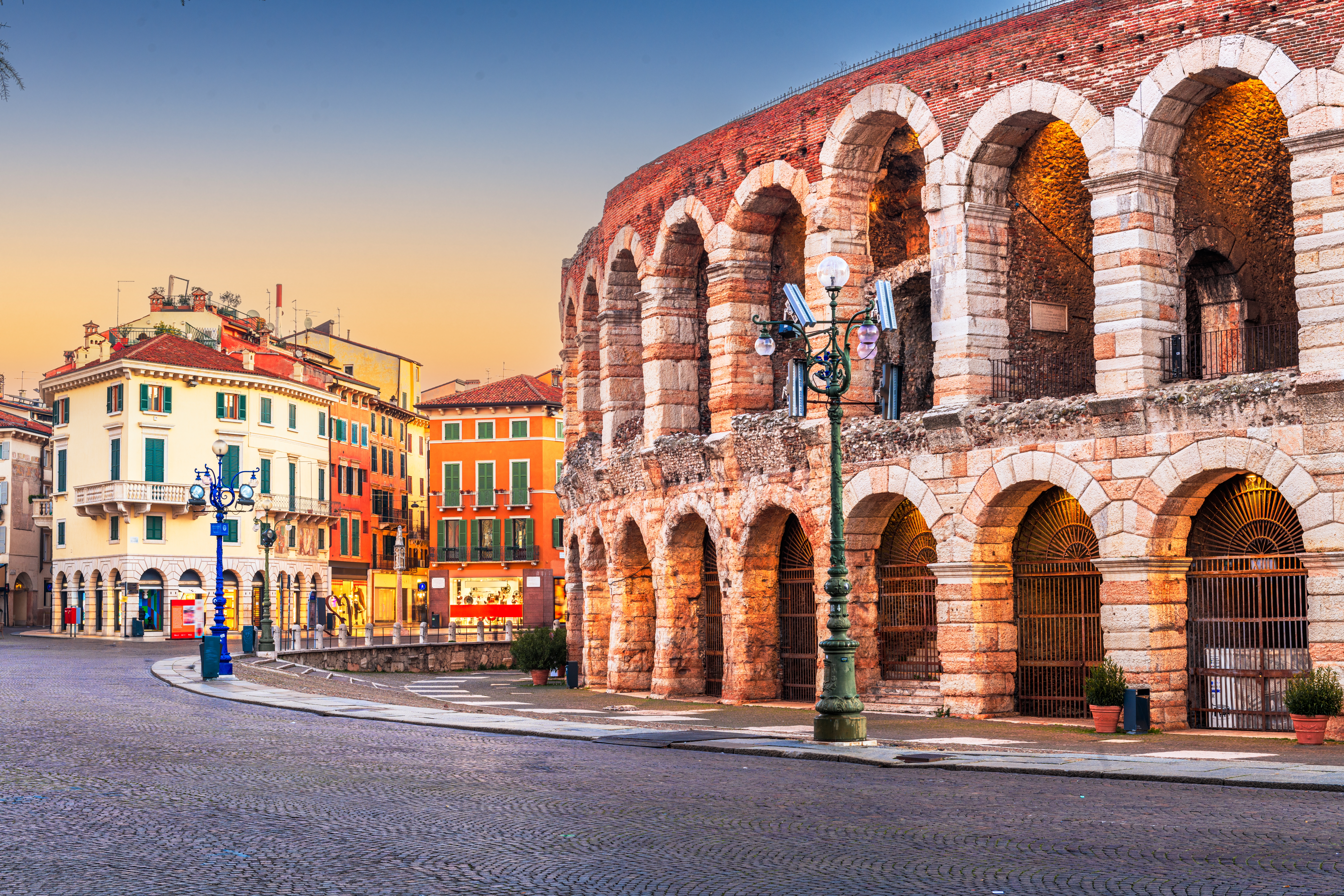 Smuk solopgang over det historiske Verona Arena og den brolagte Piazza Bra i hjertet af Verona, Italien