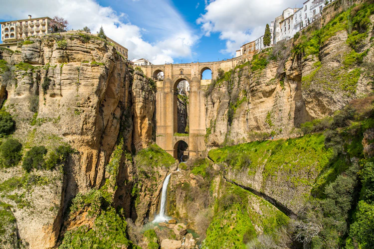 Den berømte Puente Nuevo bro i Ronda, der krydser den dybe El Tajo kløft med Guadalevín-floden og vandfald, omgivet af hvide bygninger i Andalusien, Sydspanien