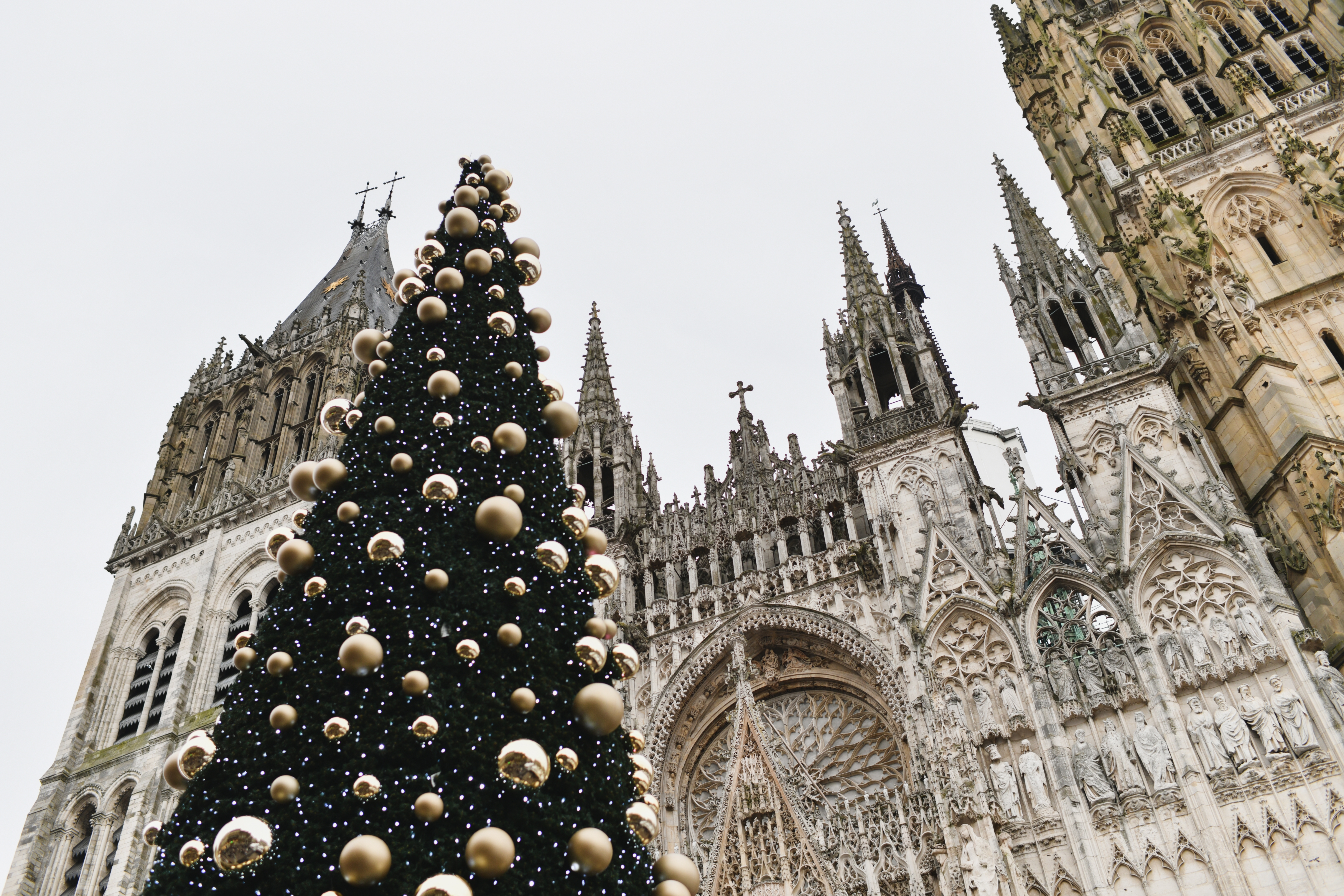 Storslået juletræ med gyldne ornamenter foran den gotiske Rouen Katedral i hjertet af Normandiet, Frankrig