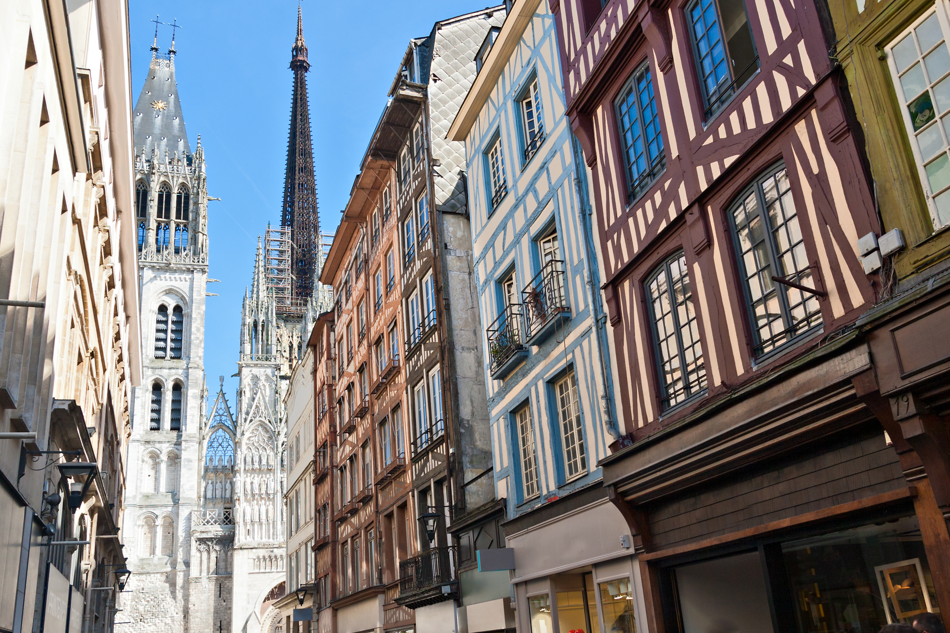 Stemningsfuld række af traditionelle franske bindingsværkshuse med synlige træbjælker og farverige facader i den historiske bykerne af Rouen, en af Normandiets mest charmerende byer