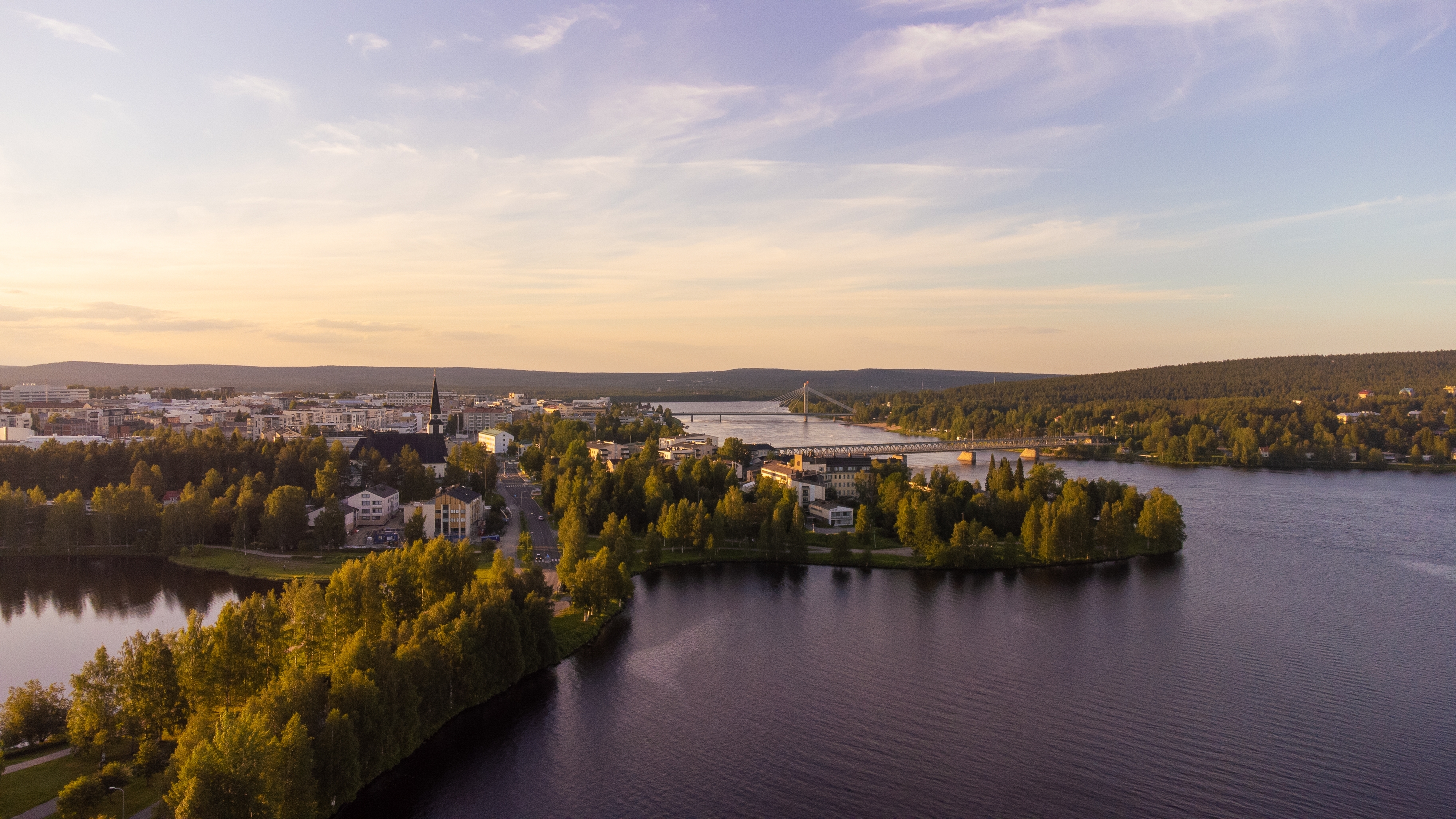 Smukt luftfoto af Rovaniemi by i finsk Lapland om sommeren med den bred Kemijoki-flod og frodig natur