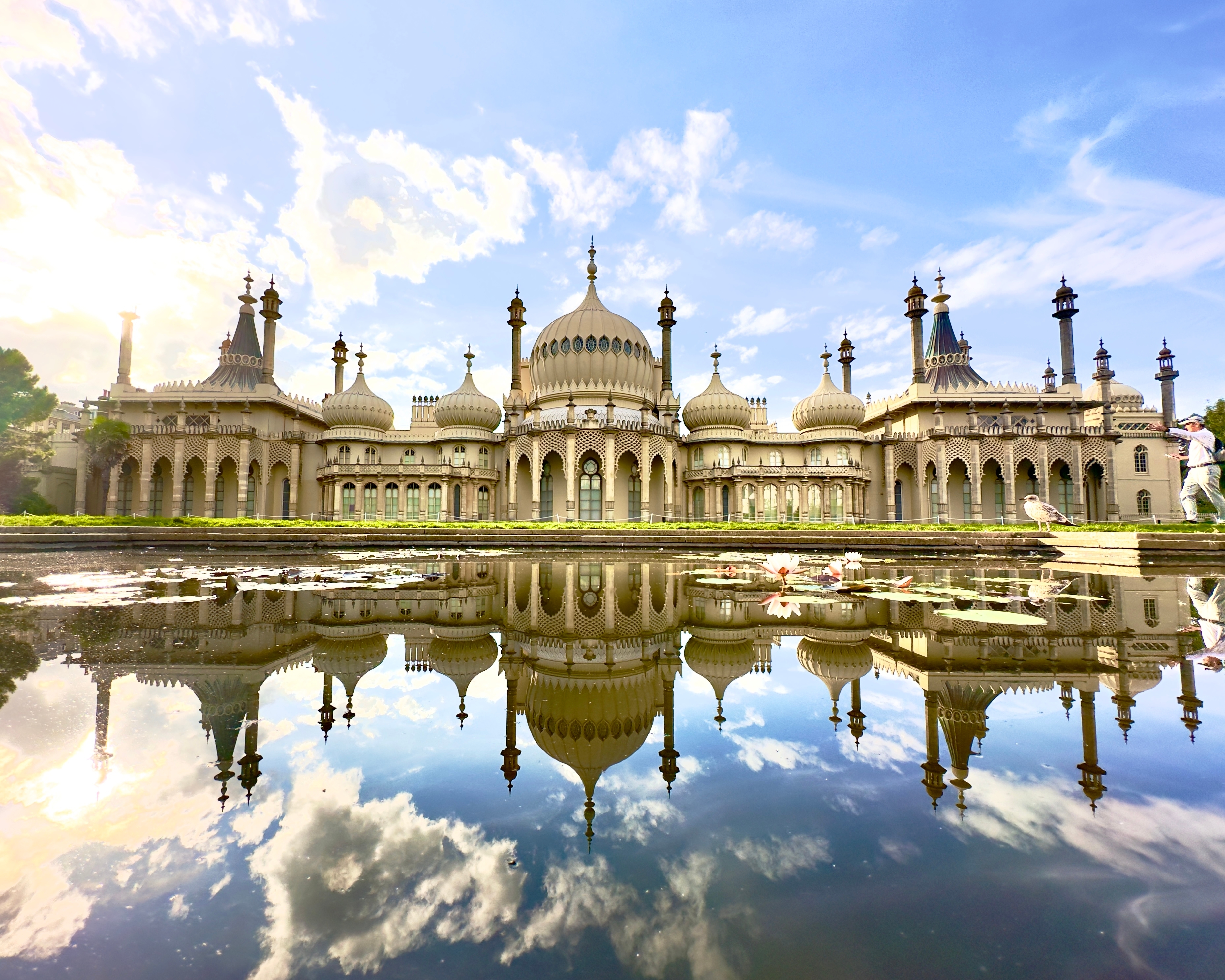 Smukke Royal Pavilion i Brighton med eksotiske kupler og minareter spejlet i en dam med åkander på en solrig dag i England