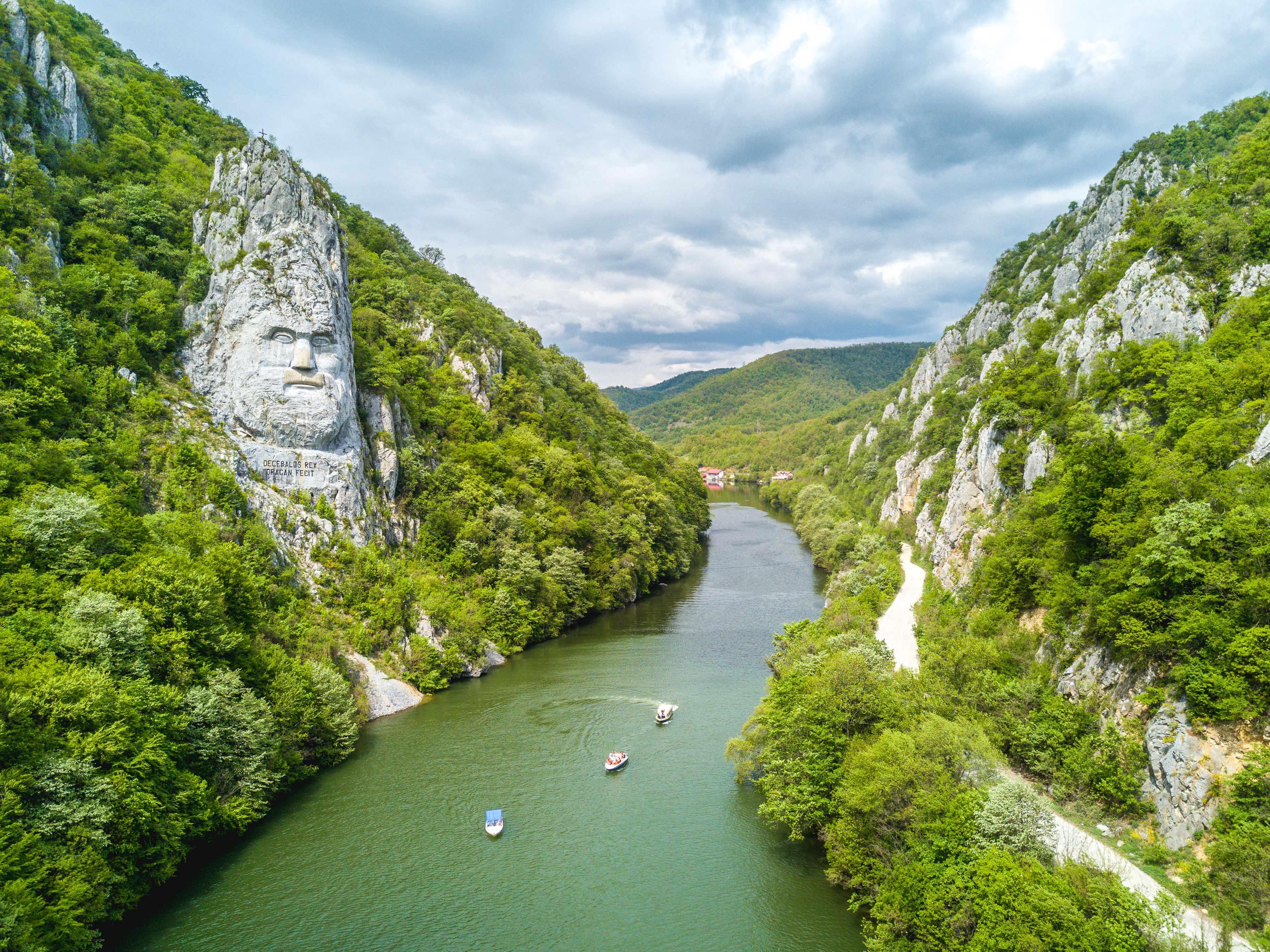 Rumænien Donau flodkrydstogt med udsigt til Decebalus kongens ansigt hugget i klippevæg mellem grønne bjerge