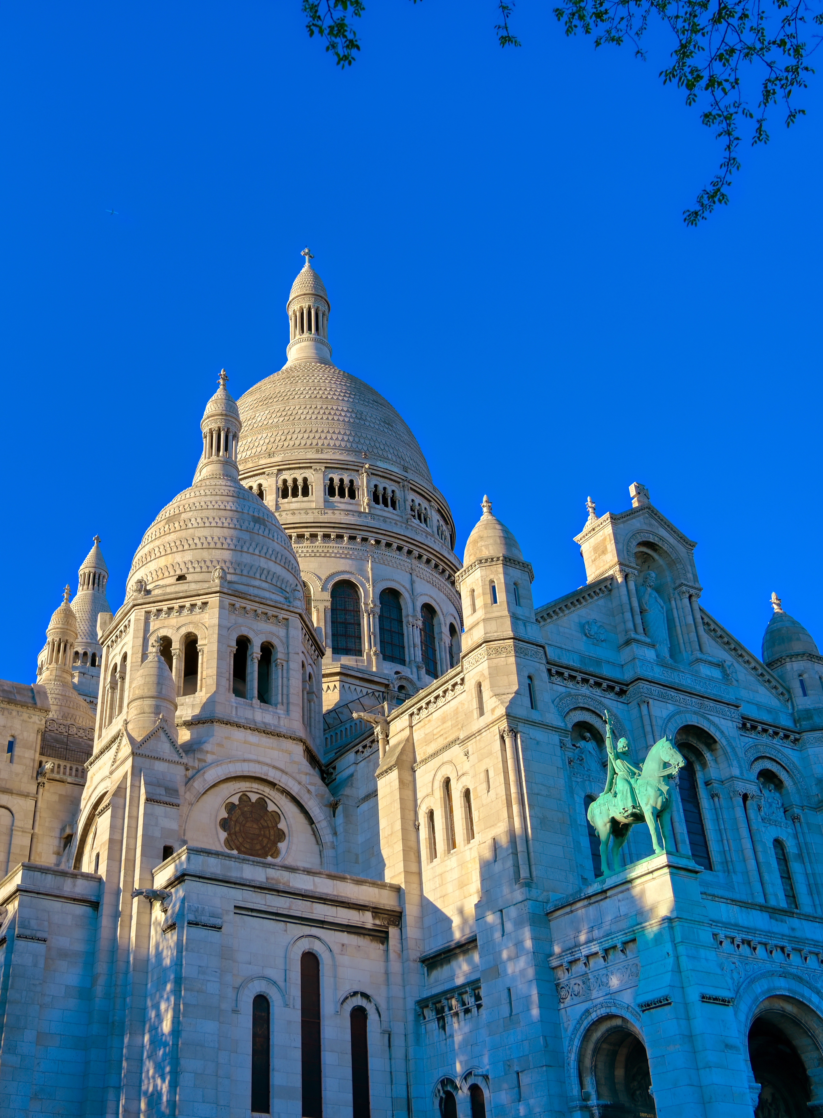 Den smukke hvide Sacré-Cœur Basilika på Montmartre-højen i Paris med karakteristiske kuplede tårne og blå himmel