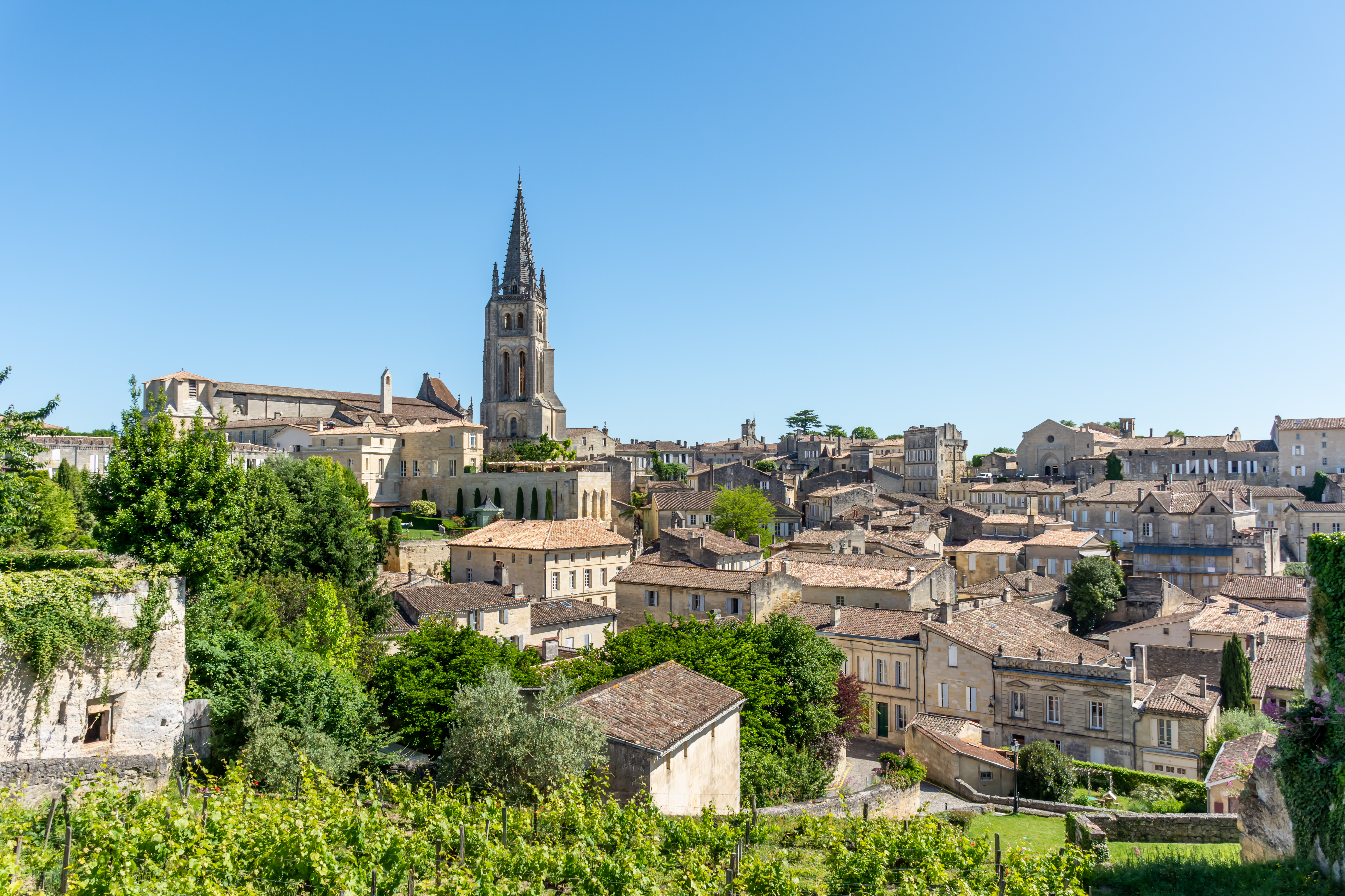 Stemningsfuld udsigt over UNESCO-byen Saint-Émilion med markant kirkespir og historiske bygninger midt i Bordeaux-vinregionen i Frankrig