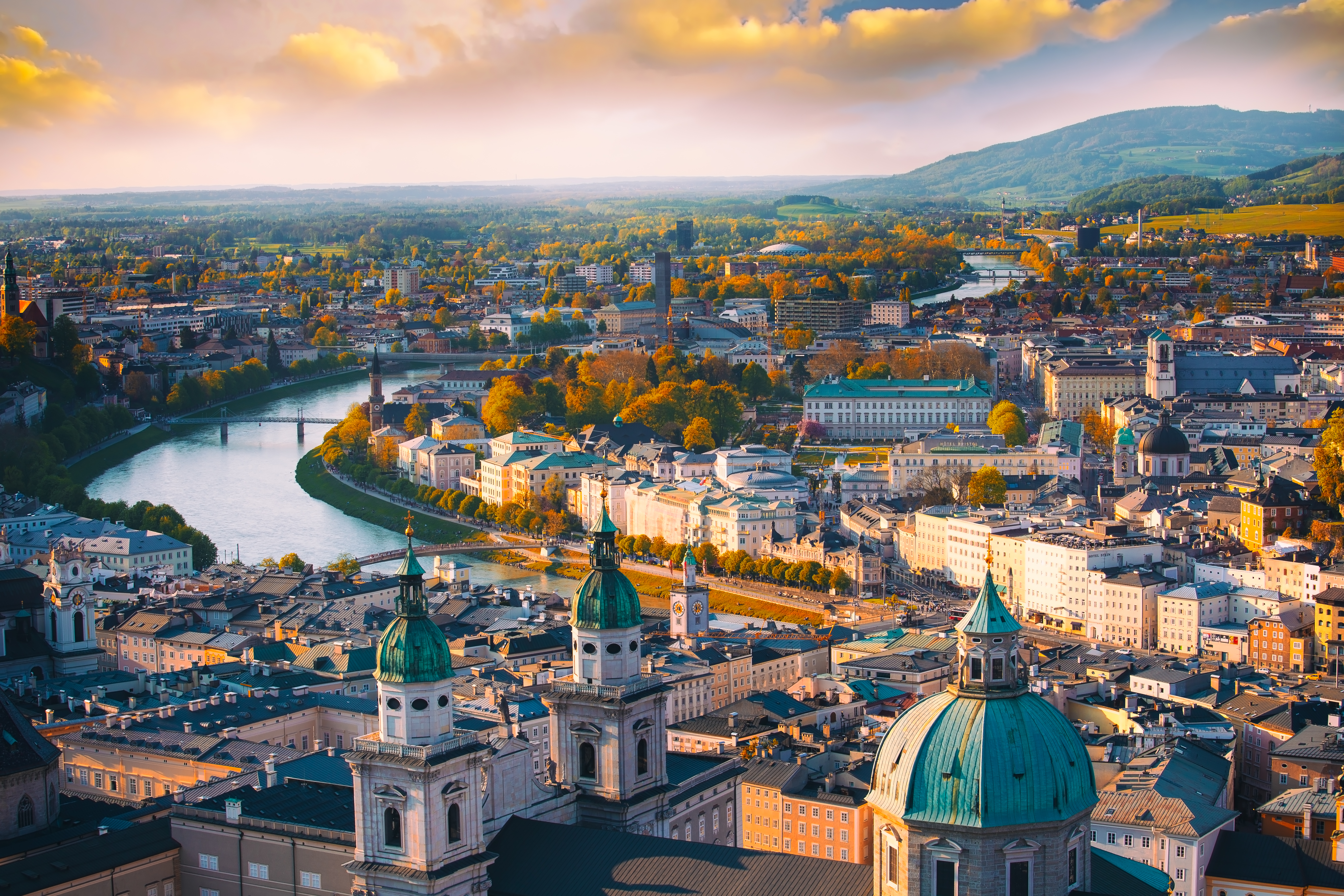 Luftbillede af Salzburg, Mozarts fødeby i Østrig, med historisk arkitektur og grønne kupler ved gylden time