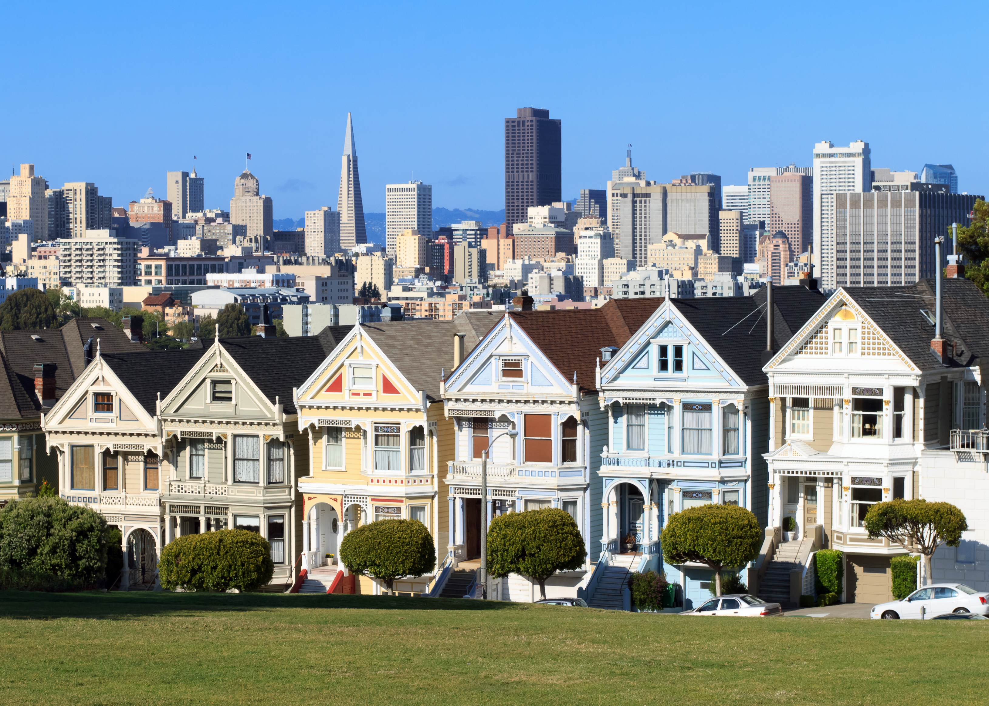 Farverige victorianske huse med San Francisco skyskrabere i baggrunden