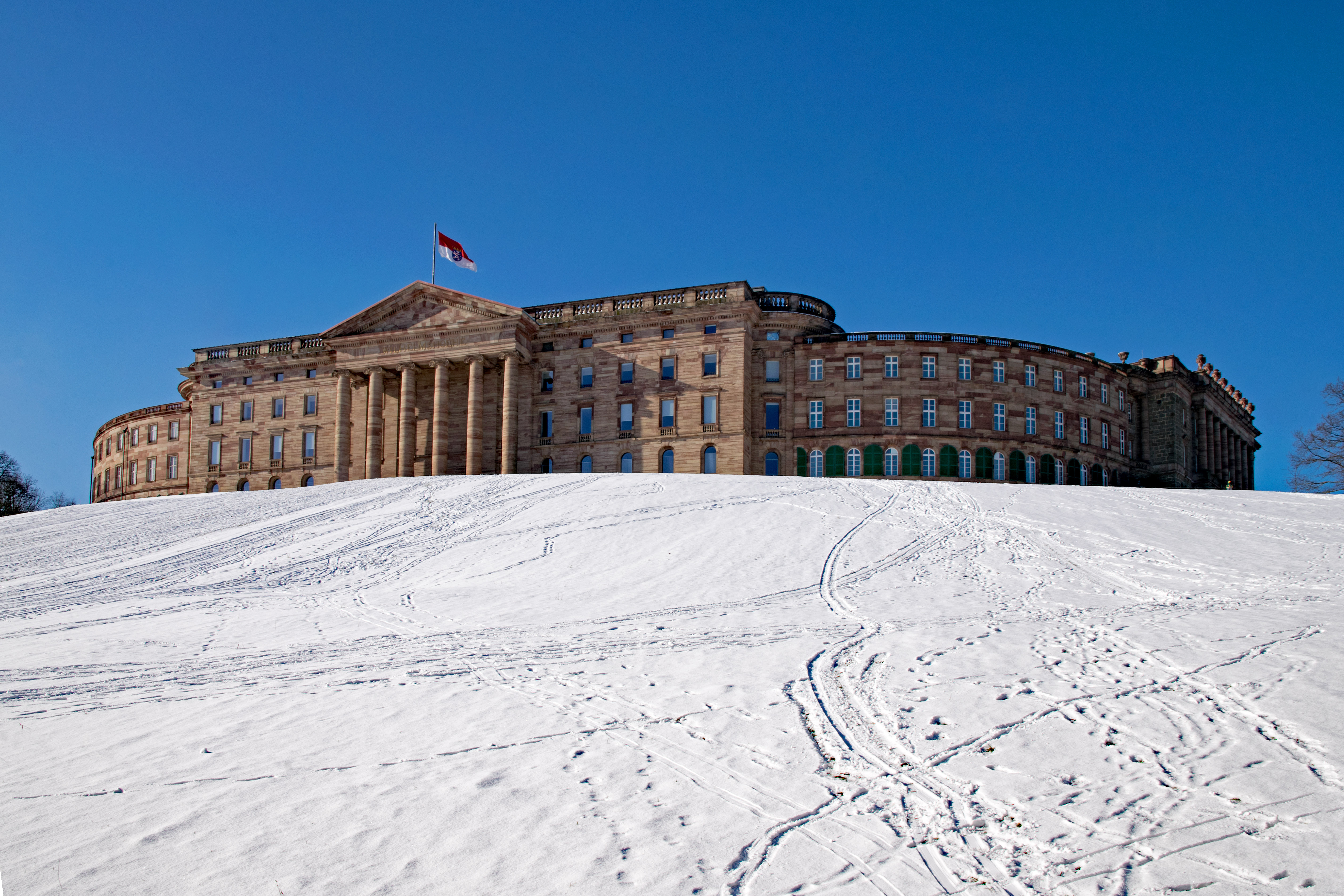 Historisk Schloss Wilhelmshöhe slot i Kassel omgivet af sne og vinterlandskab i Hessen, Tyskland