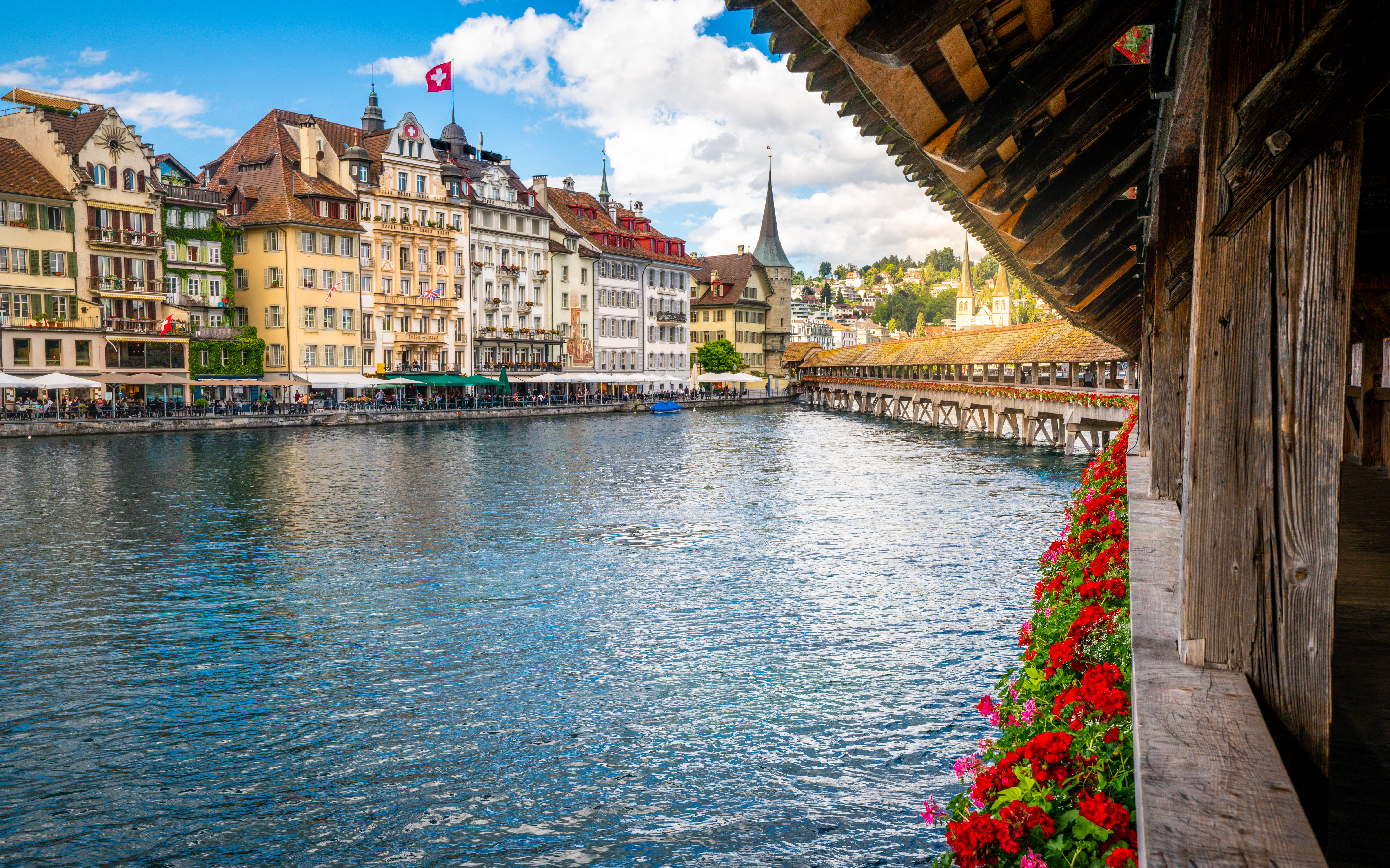 Historisk udsigt over Chapel Bridge og den charmerende gamle bydel i Lucerne med blomsterdekorationer