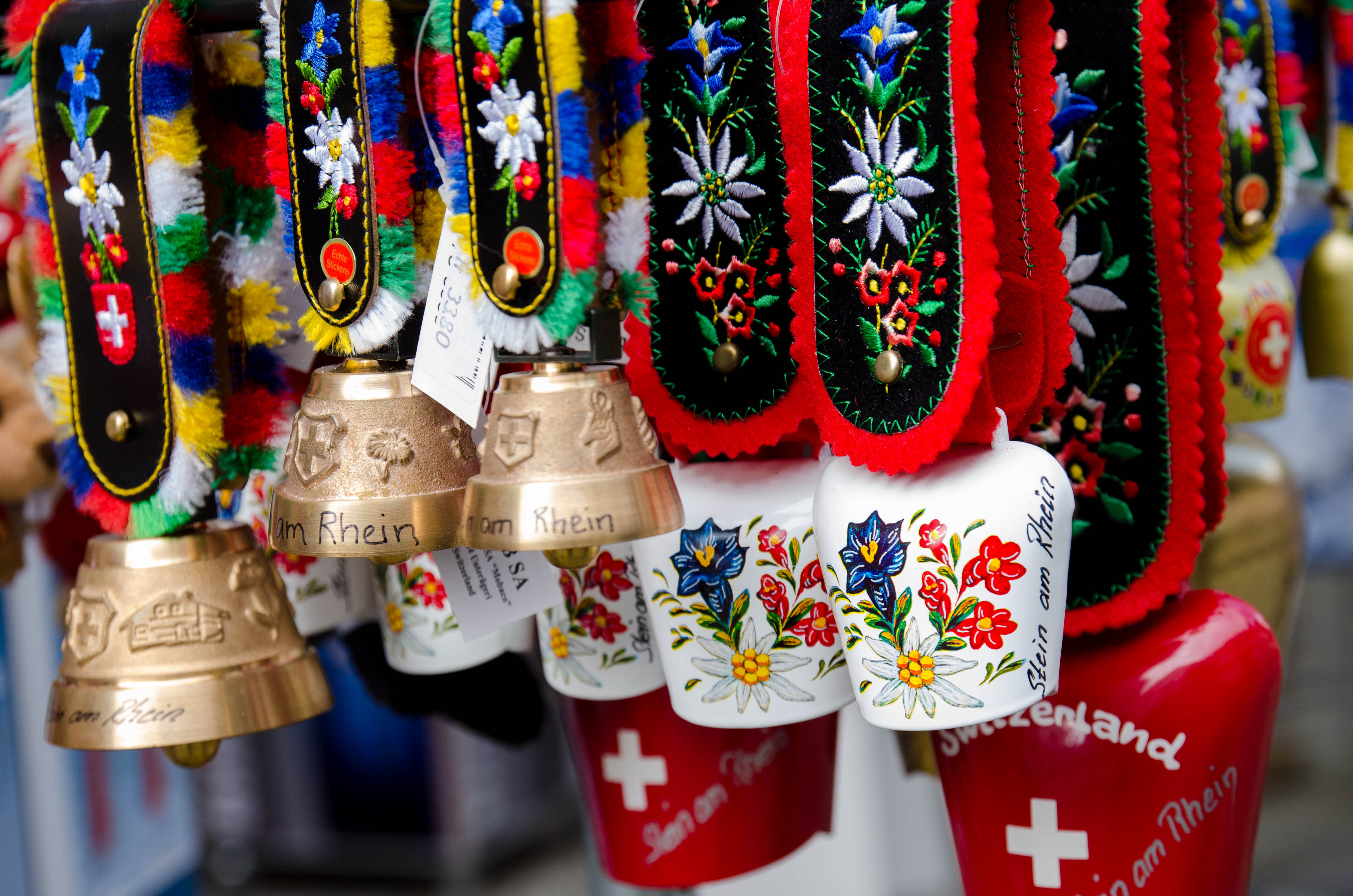 Håndlavede schweiziske koklokker med farverige broderede remme og schweizerflag, typiske souvenirs fra Stein am Rhein