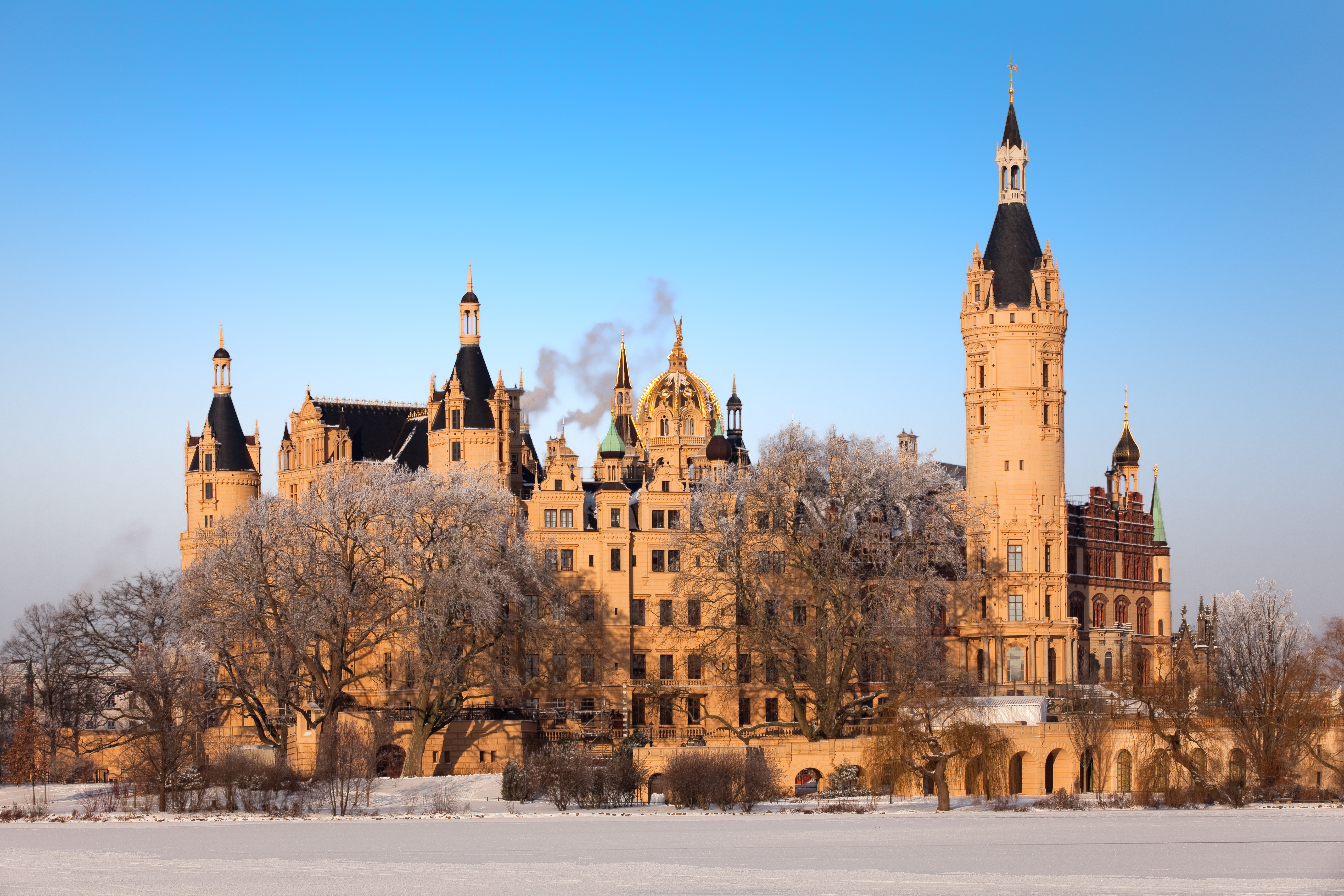 Det smukke historiske Schwerin Slot med gyldne tårne i vinterlandskab med sne og is i Mecklenburg, Tyskland