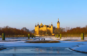 Schwerin Slot om vinteren med snedækkede haver og frossen sø i Tyskland