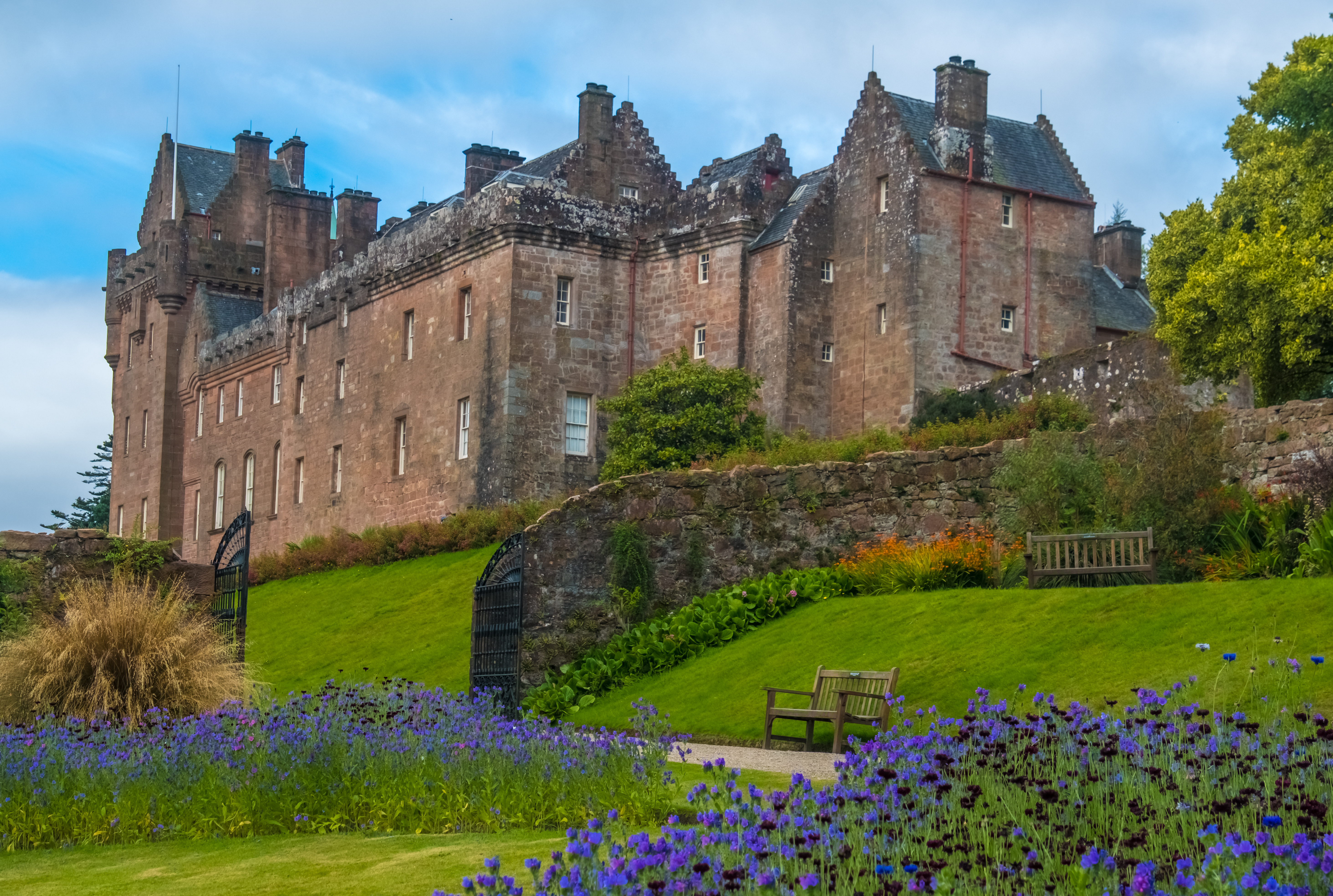 Majestætisk Brodick Castle på Isle of Arran med pragtfuld have fyldt med lilla blomster