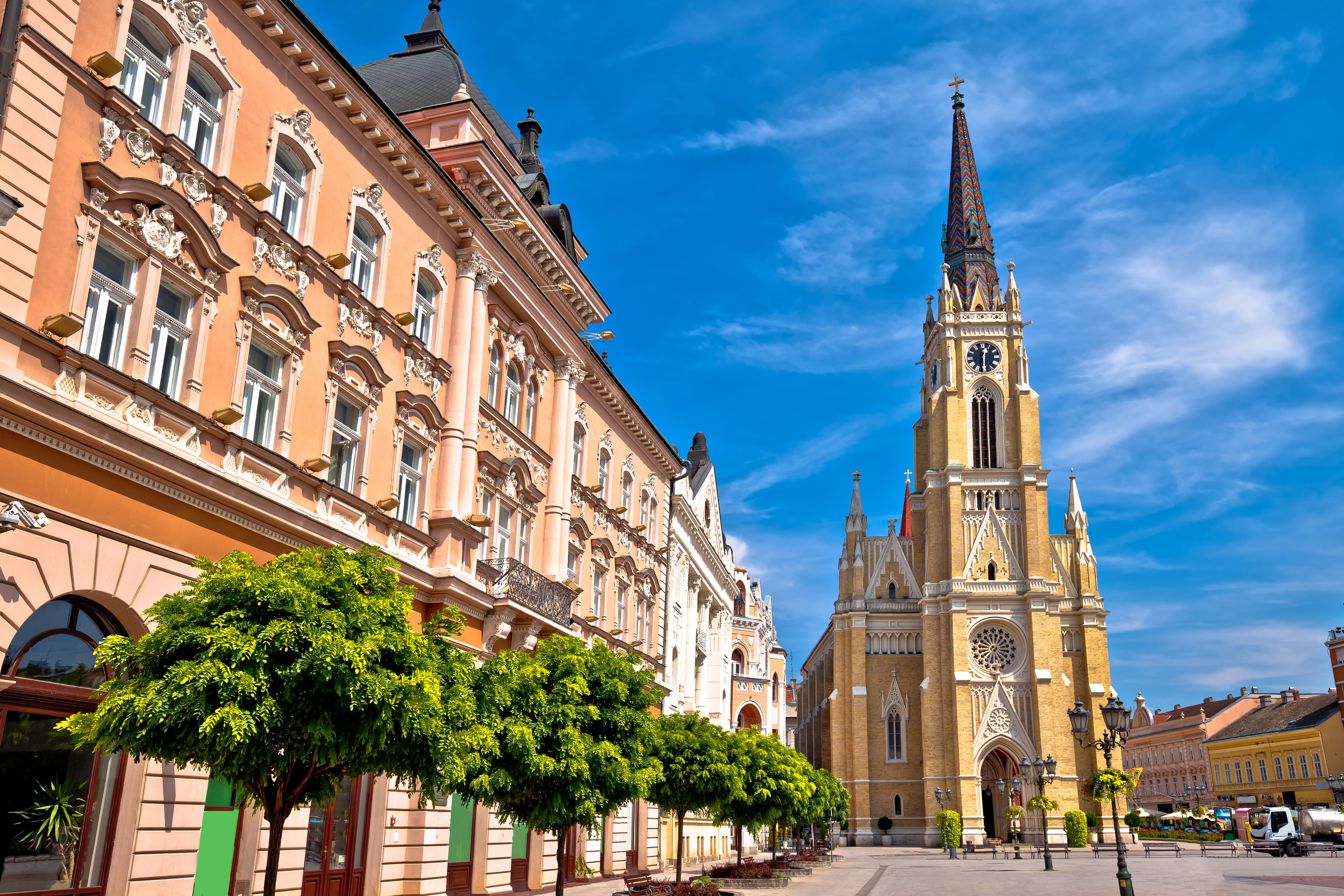 Majestætisk katedral og orange bygninger på det centrale torv i Novi Sad