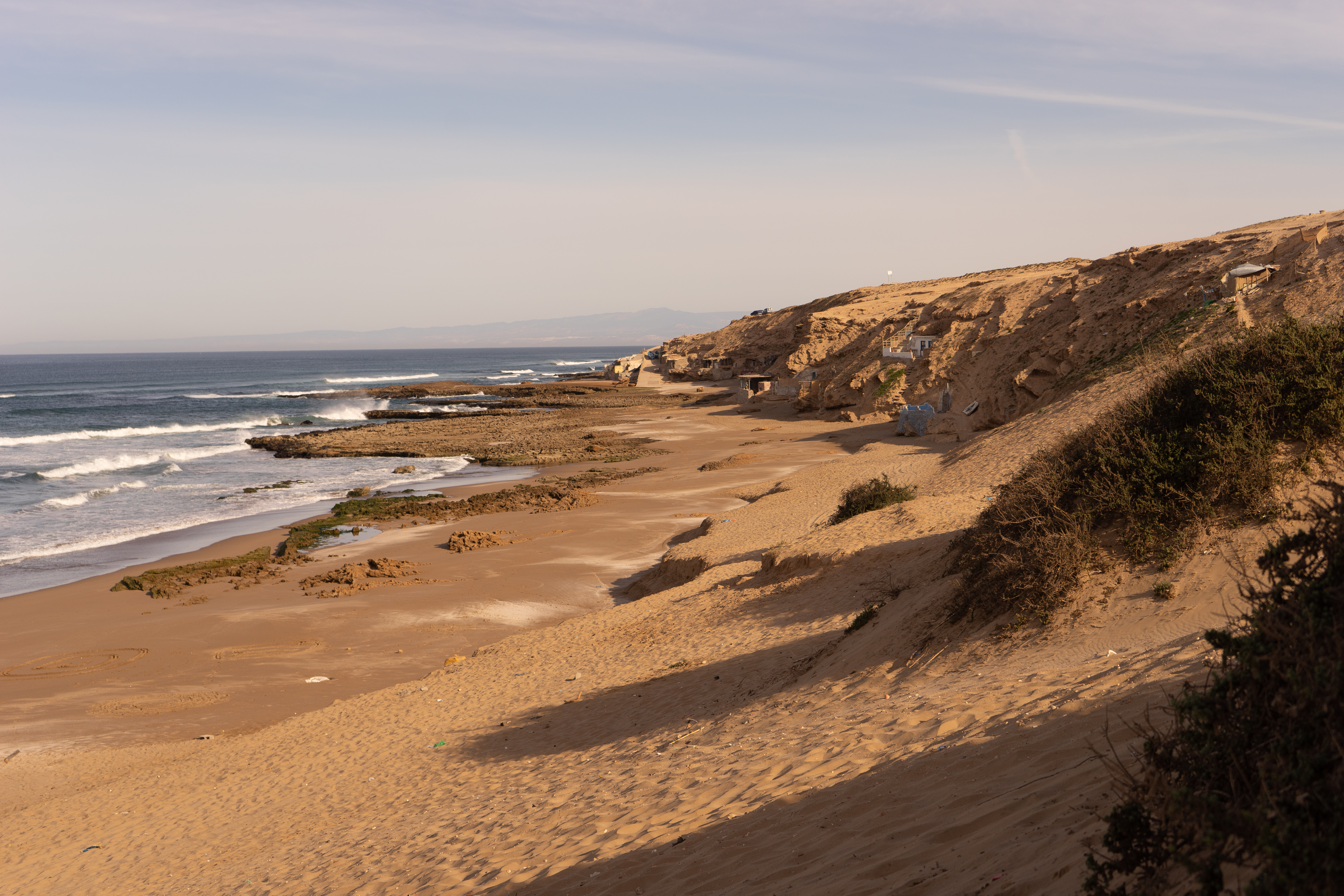 Naturskøn sandstrand med klitter og klippekyster i Souss-Massa Nationalpark nær Sidi Rbat i Sydmarokko