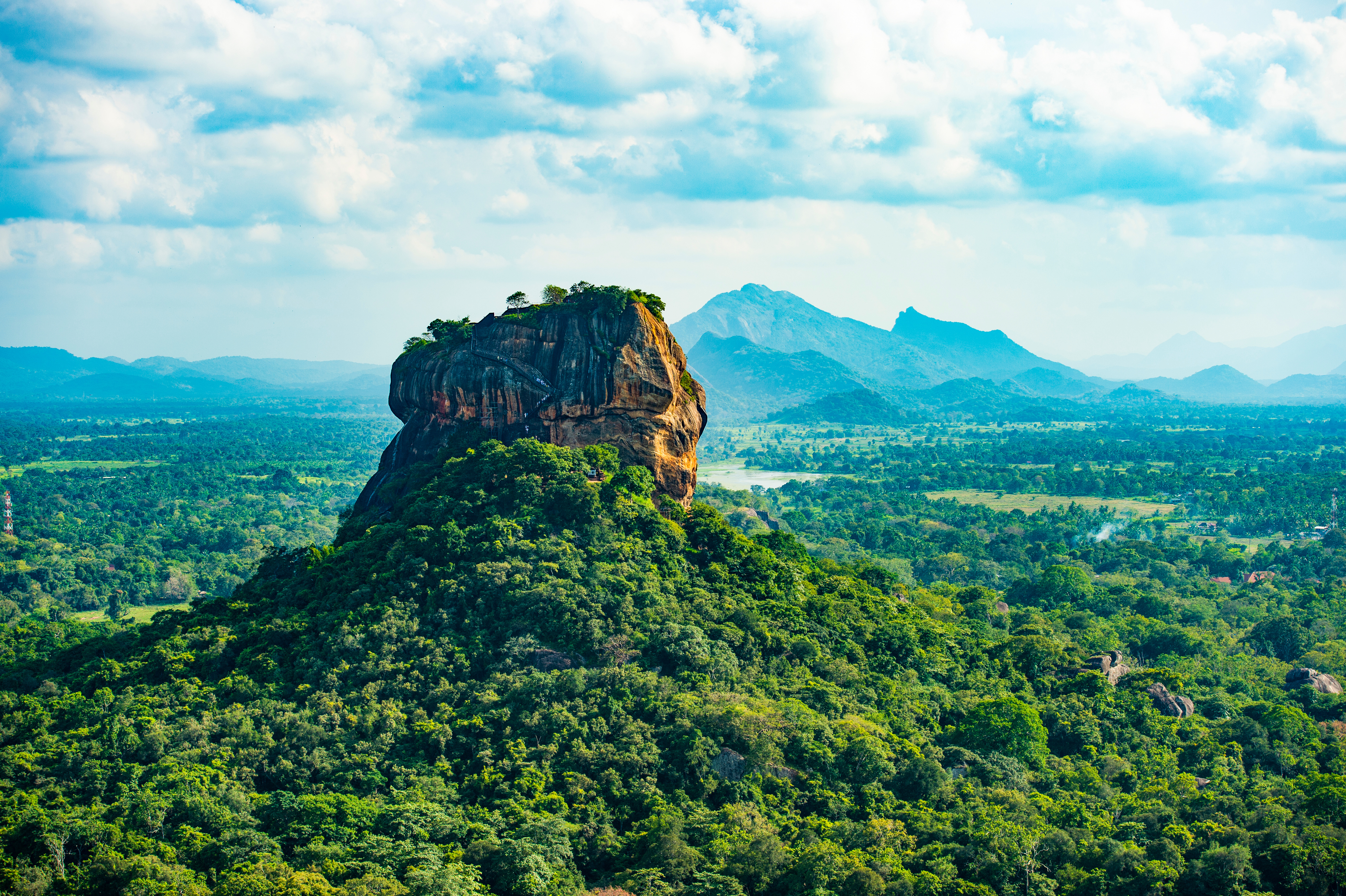 UNESCO-verdensarv Sigiriya-klippen set fra Pidurangala Rock omgivet af frodig tropisk vegetation i Sri Lanka