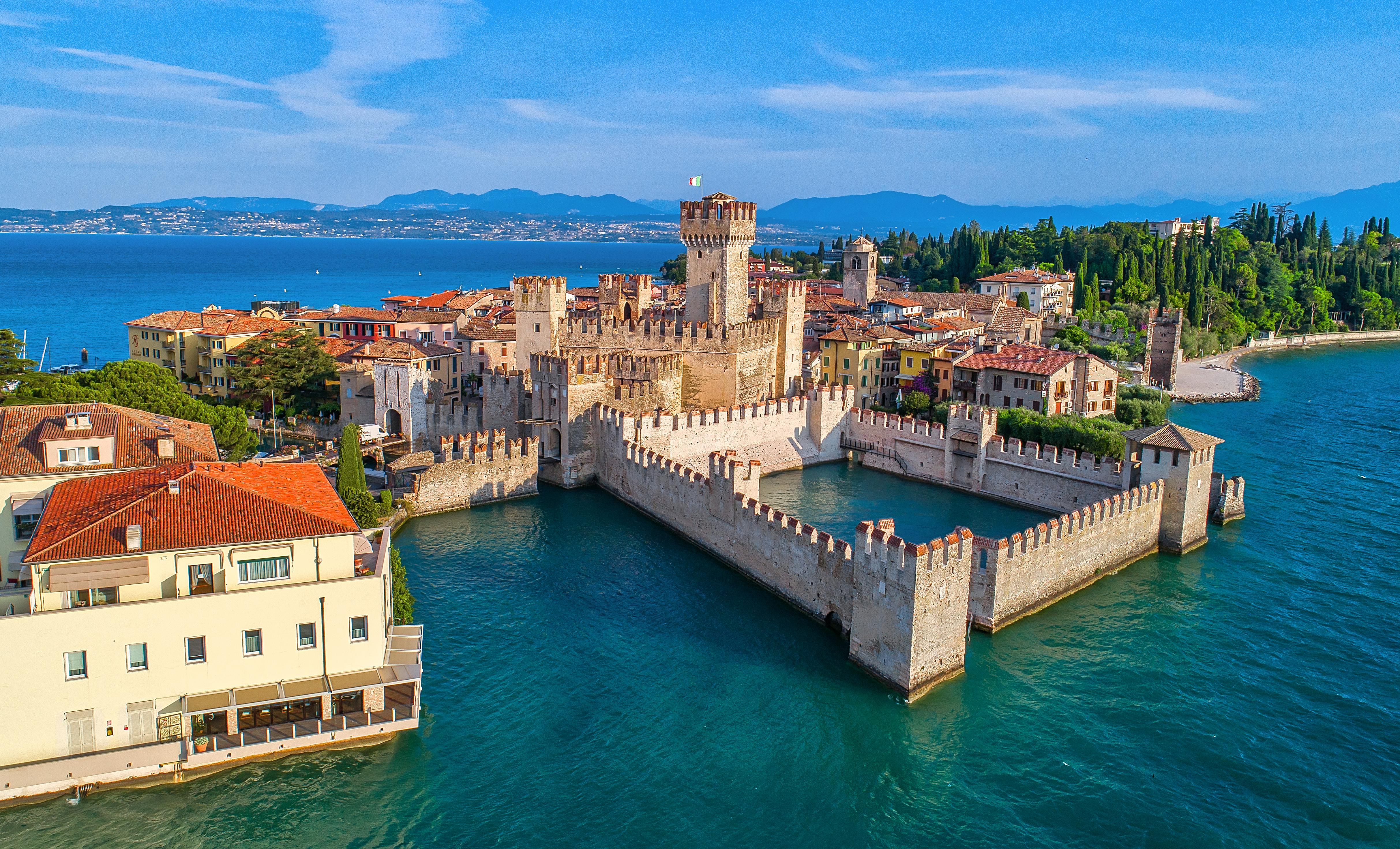 Betagende luftfoto af Sirmione med det ikoniske slot og den historiske bymidte på en halvø i den smukke Gardasø
