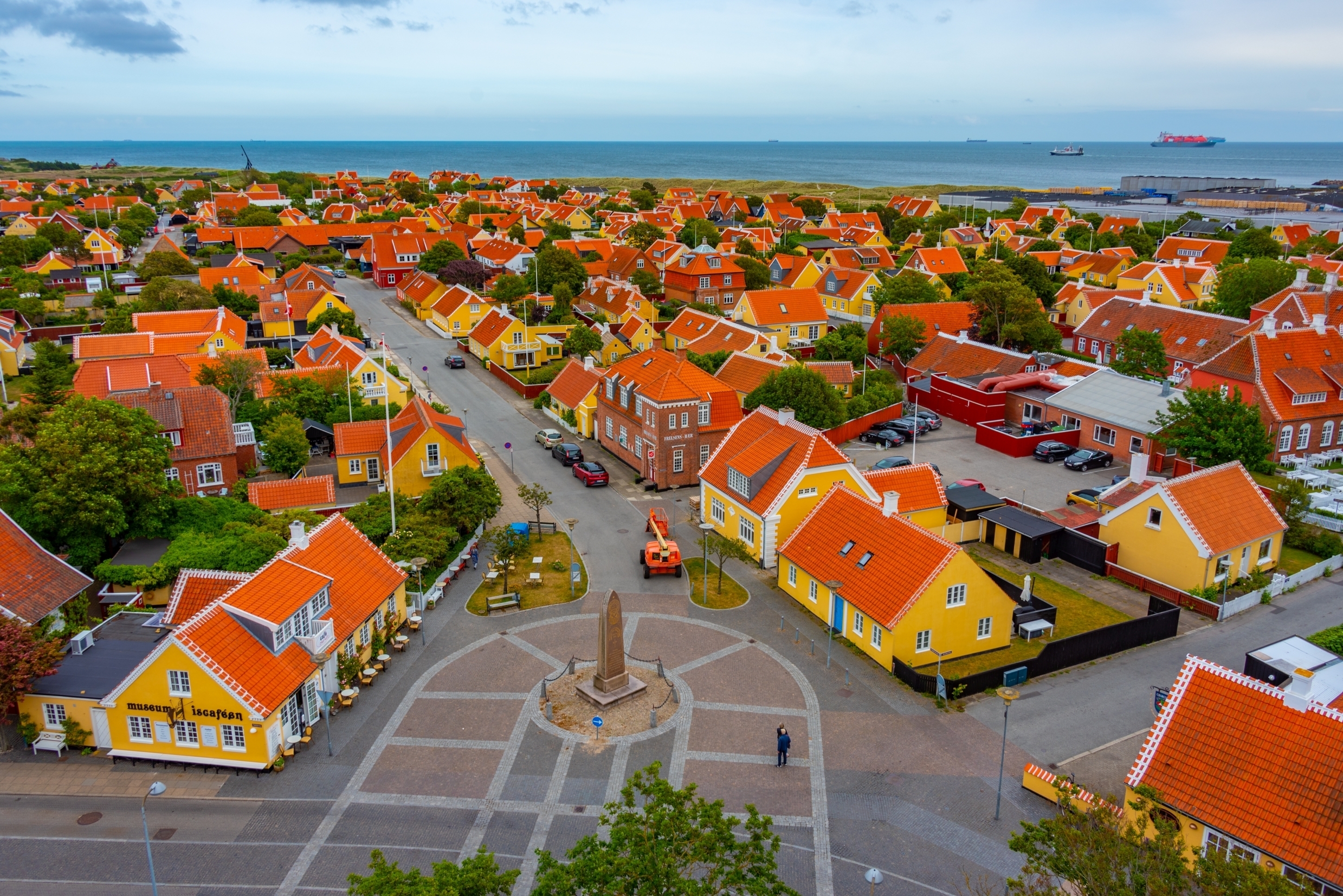 Luftfoto af det maleriske Skagen i Nordjylland med traditionelle gule huse, røde tage og udsigt til havet