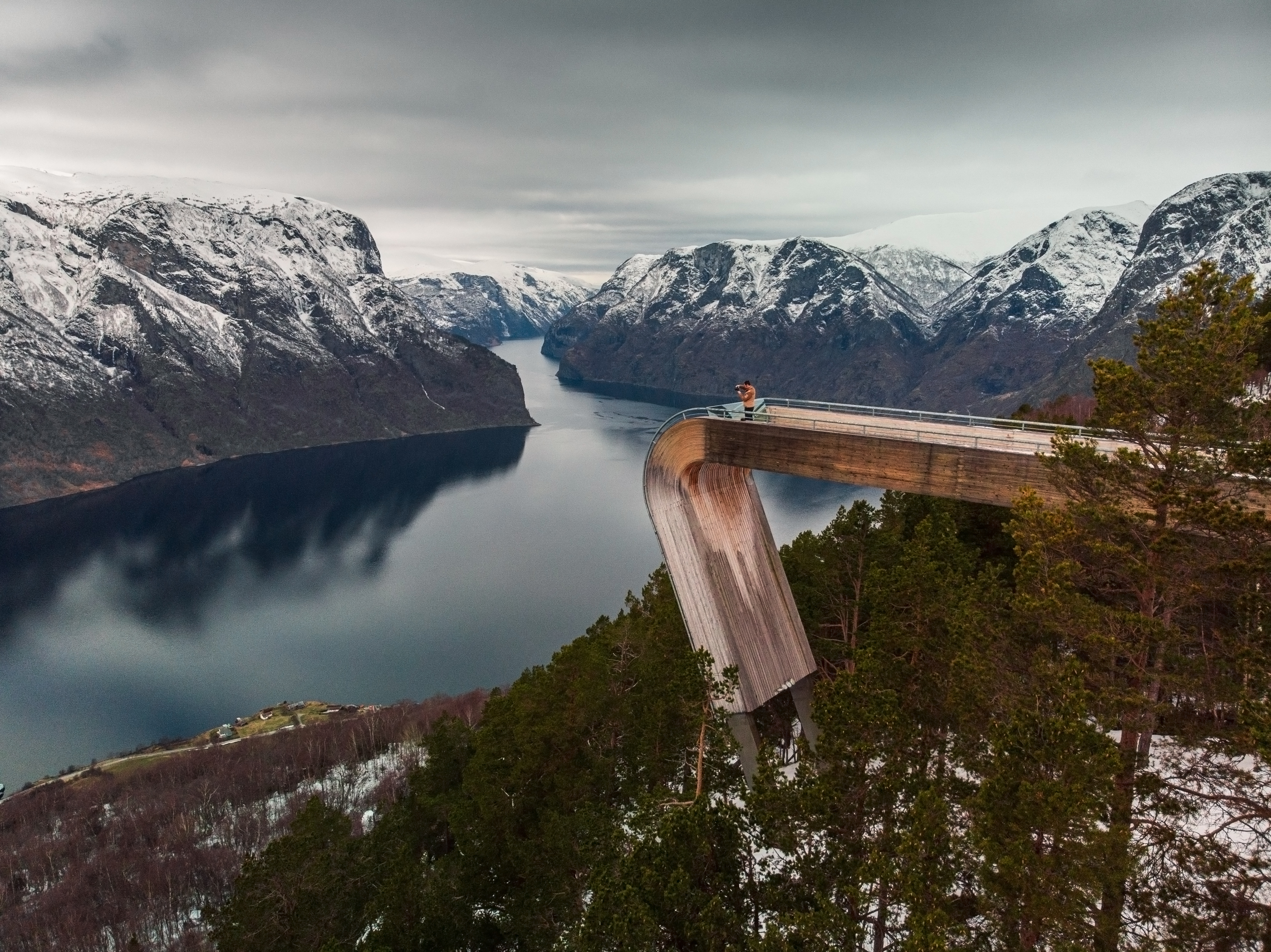 Rejsende på Stegastein udsigtsplatform nyder det majestætiske vinterlandskab ved Aurlandsfjorden