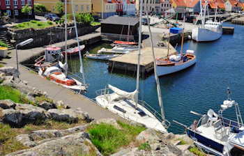 Idyllisk skandinavisk fiskerby med havn og sejlbåde
