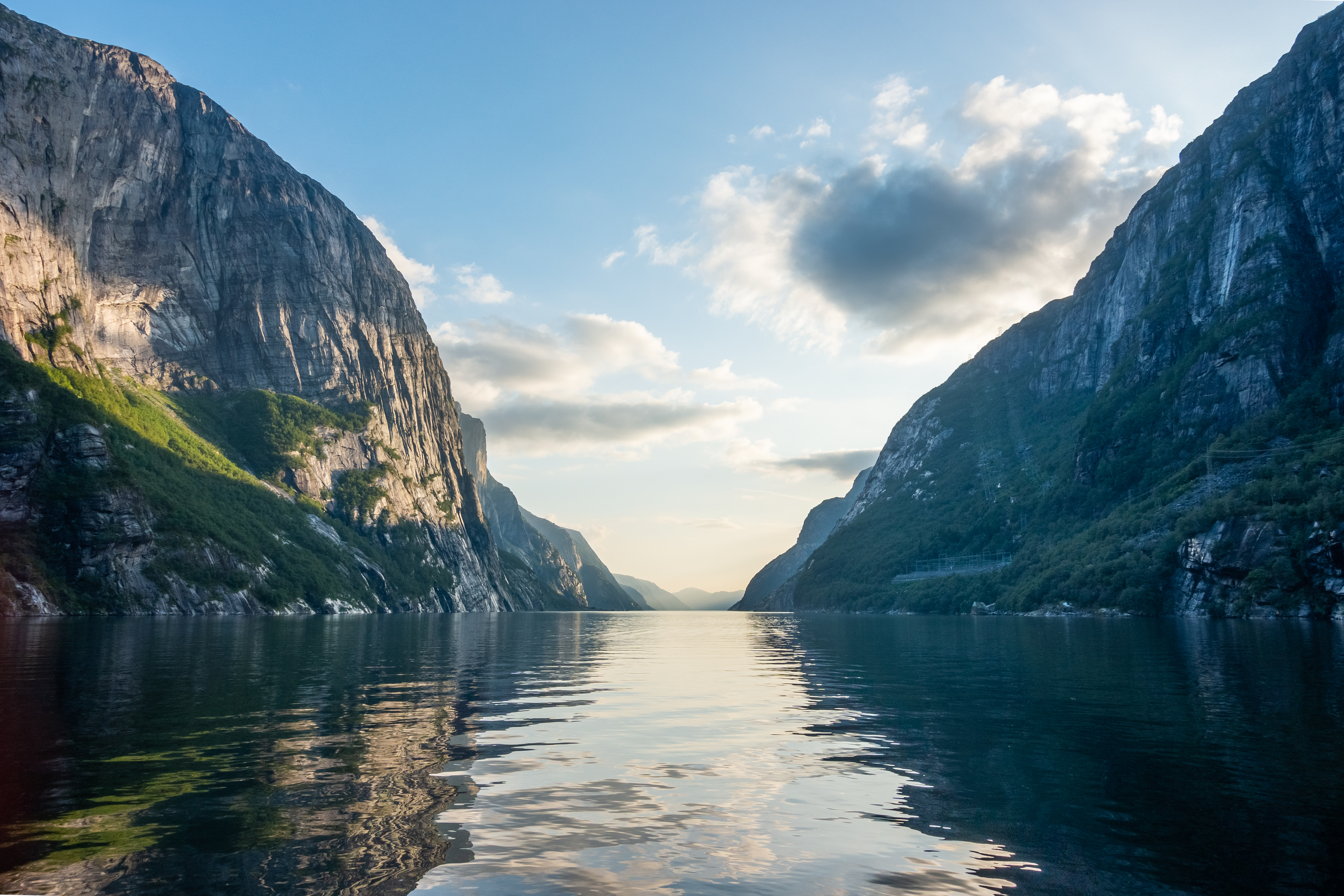 Idyllisk skandinavisk fjordlandskab med imponerende klipper og gylden aftenlys