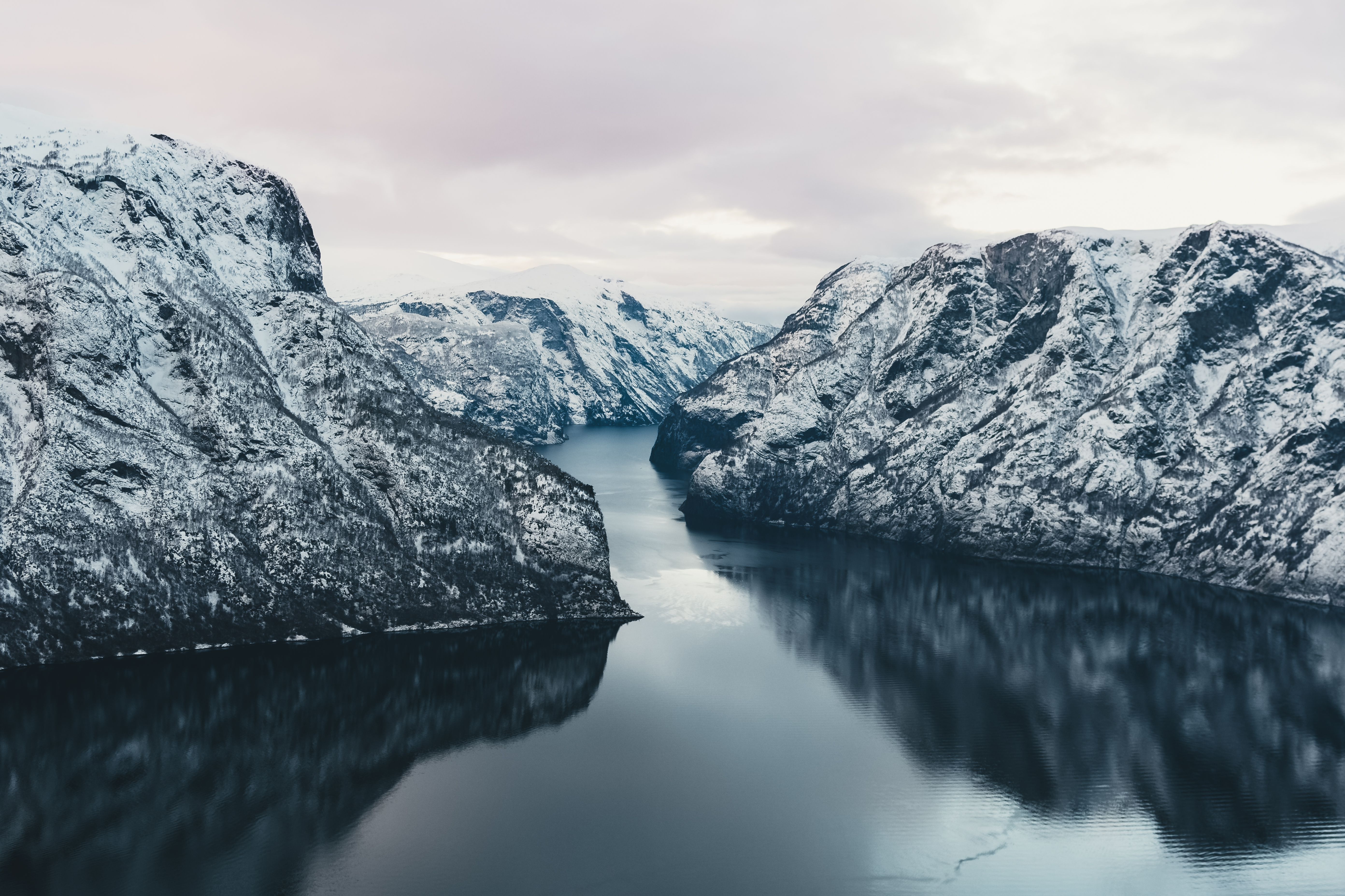 Fantastisk norsk fjordlandskab med hoeje snedaekte bjerge og spejlblankt vand