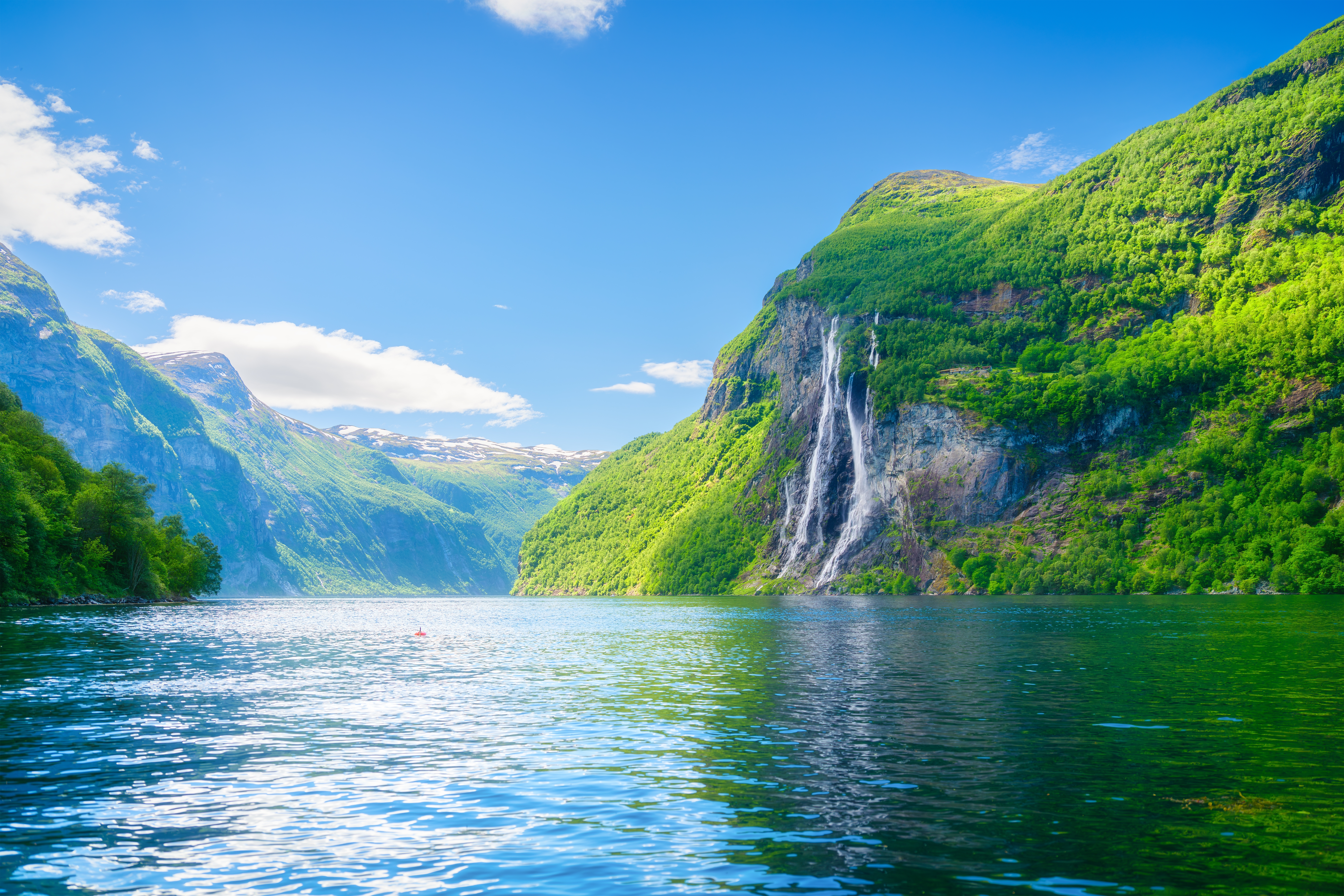 UNESCO beskyttet skandinavisk fjordlandskab med højt vandfald og krystalklart blåt fjordvand