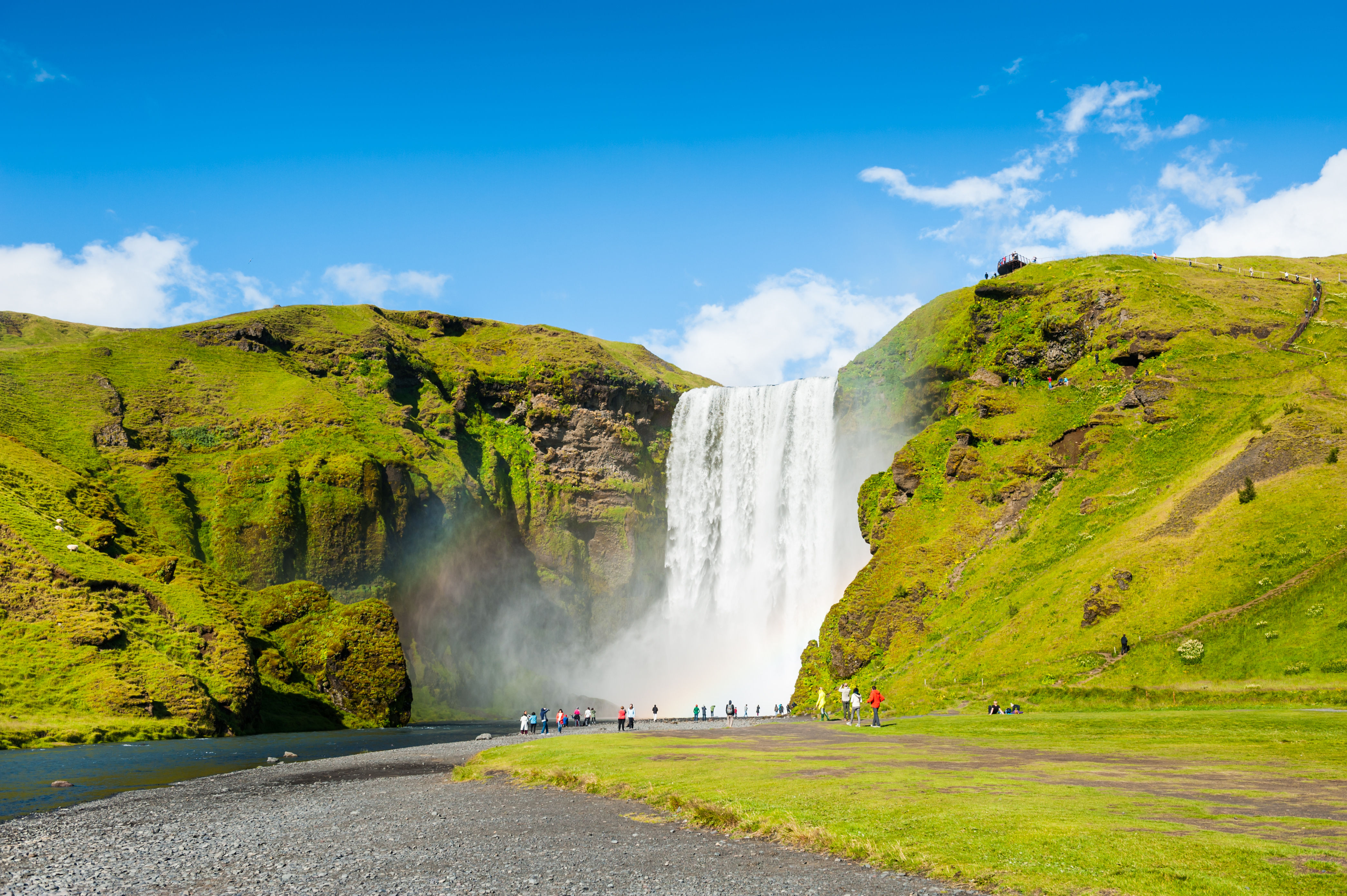 Storslået Skógafoss vandfald på Island med turister der oplever Islands fantastiske natur