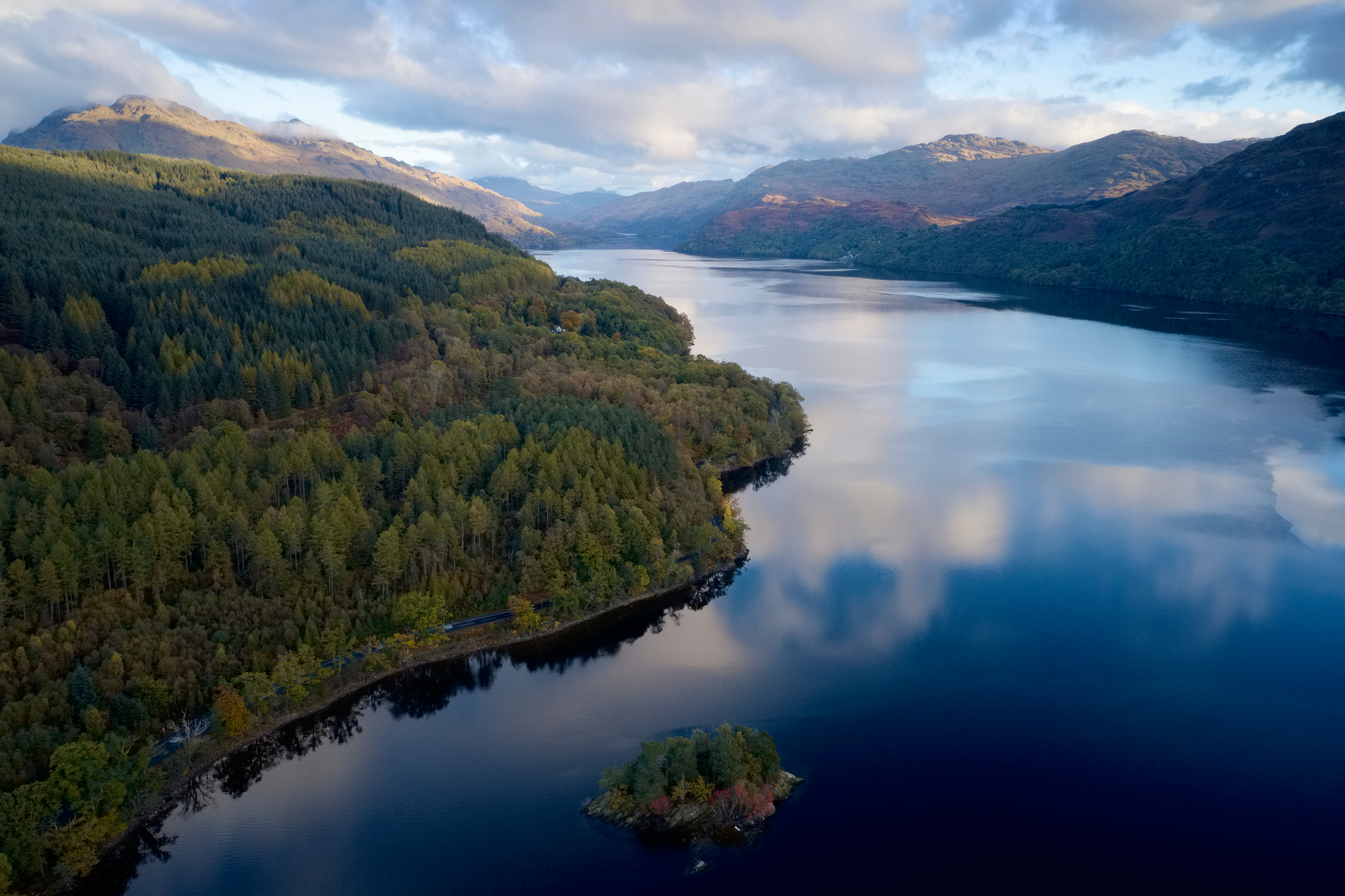 Fredelig Loch Lomond omgivet af efterårsfarver og dramatiske skotske Highlands