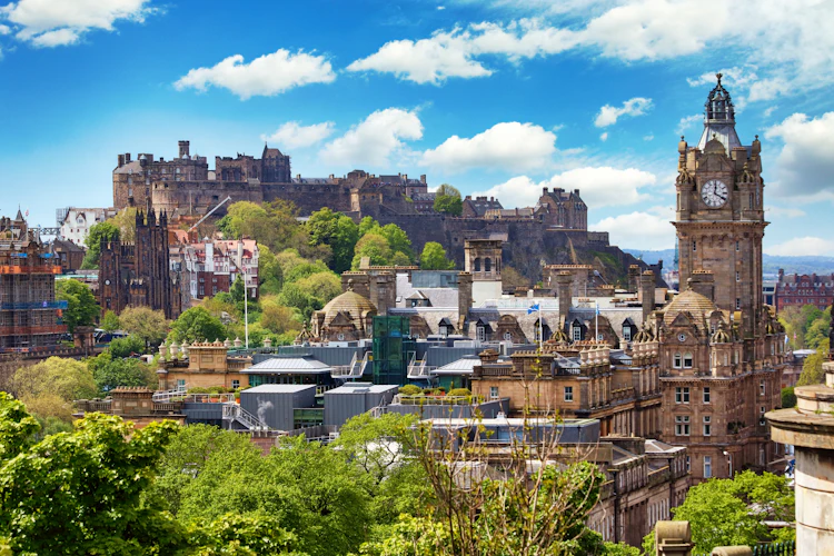 Panoramaudsigt over Edinburgh med det majestætiske Edinburgh Castle på klippetoppen og Balmoral Hotels klokketårn omgivet af historiske bygninger i Skotland