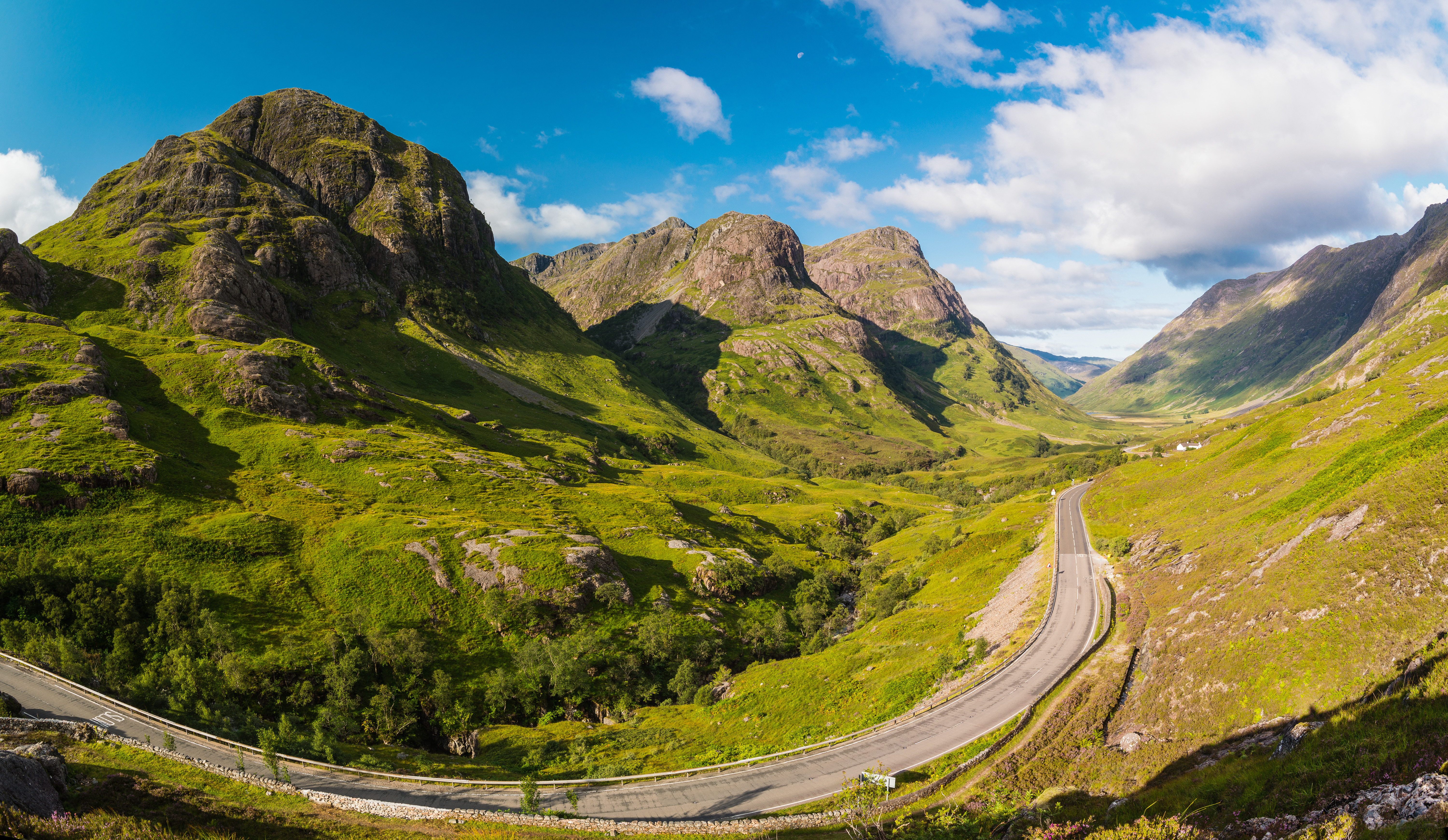 Panoramaudsigt over den berømte Glen Coe dal med dramatiske bjerge og grønne skråninger
