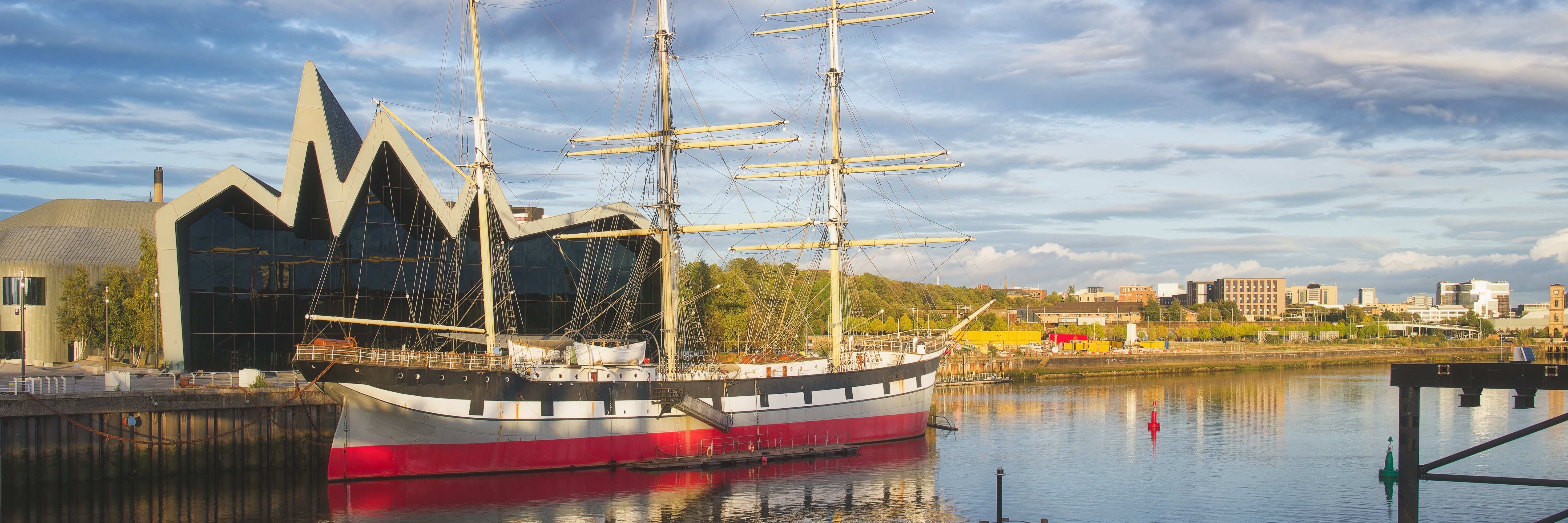Glasgow havn med historisk sejlskib og moderne museumsbyggeri