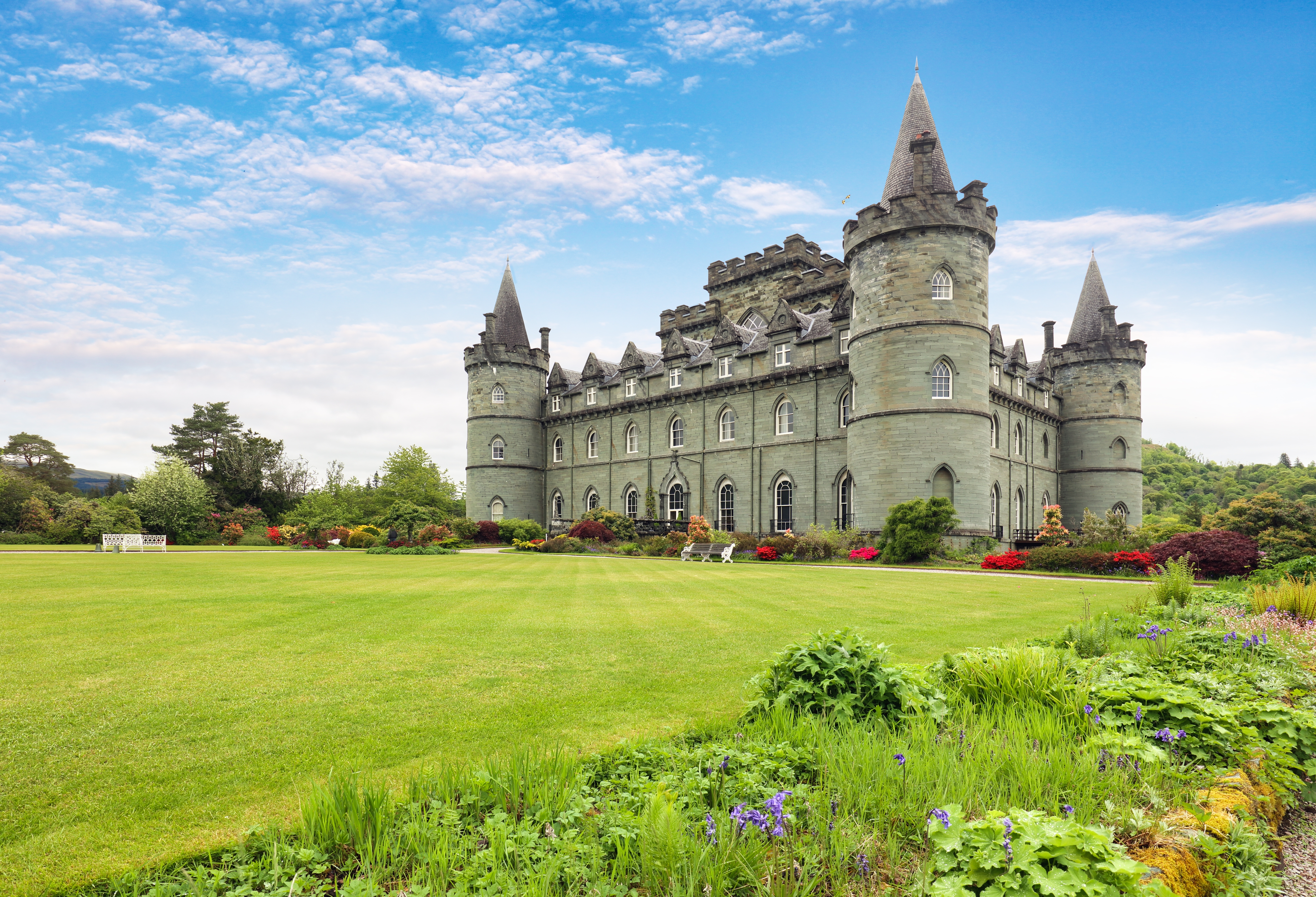 Smukke Inveraray Castle i Skotland med eventyrlige tårne og blomstrende haver på en solrig sommerdag