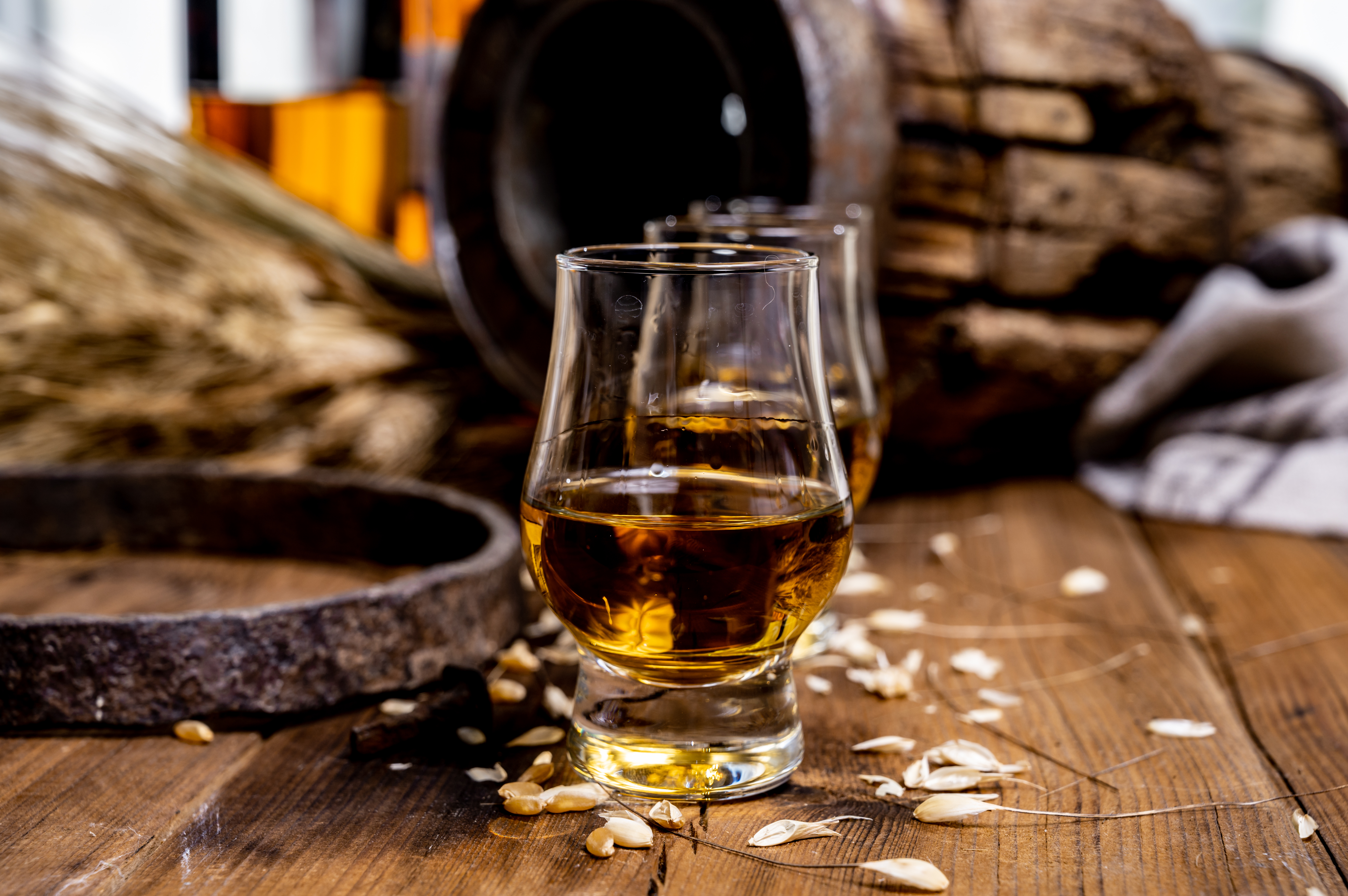 Traditionel whisky smagning med glas på traeunderlag og fade baggrund