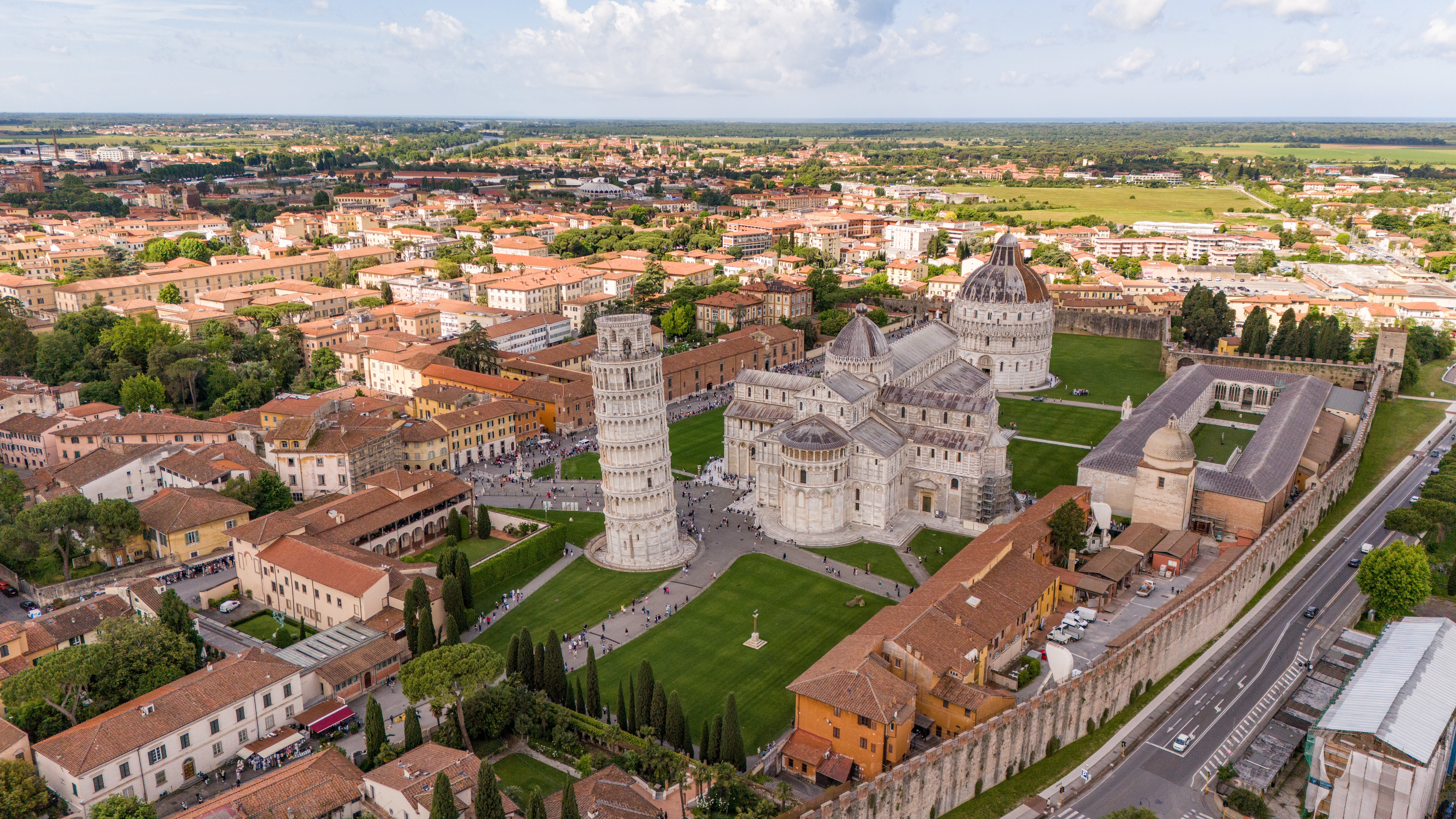 Luftfoto af det verdenskendte skæve tårn i Pisa med den imponerende domkirke og det runde baptisteri på Mirakelpladsen i Italien