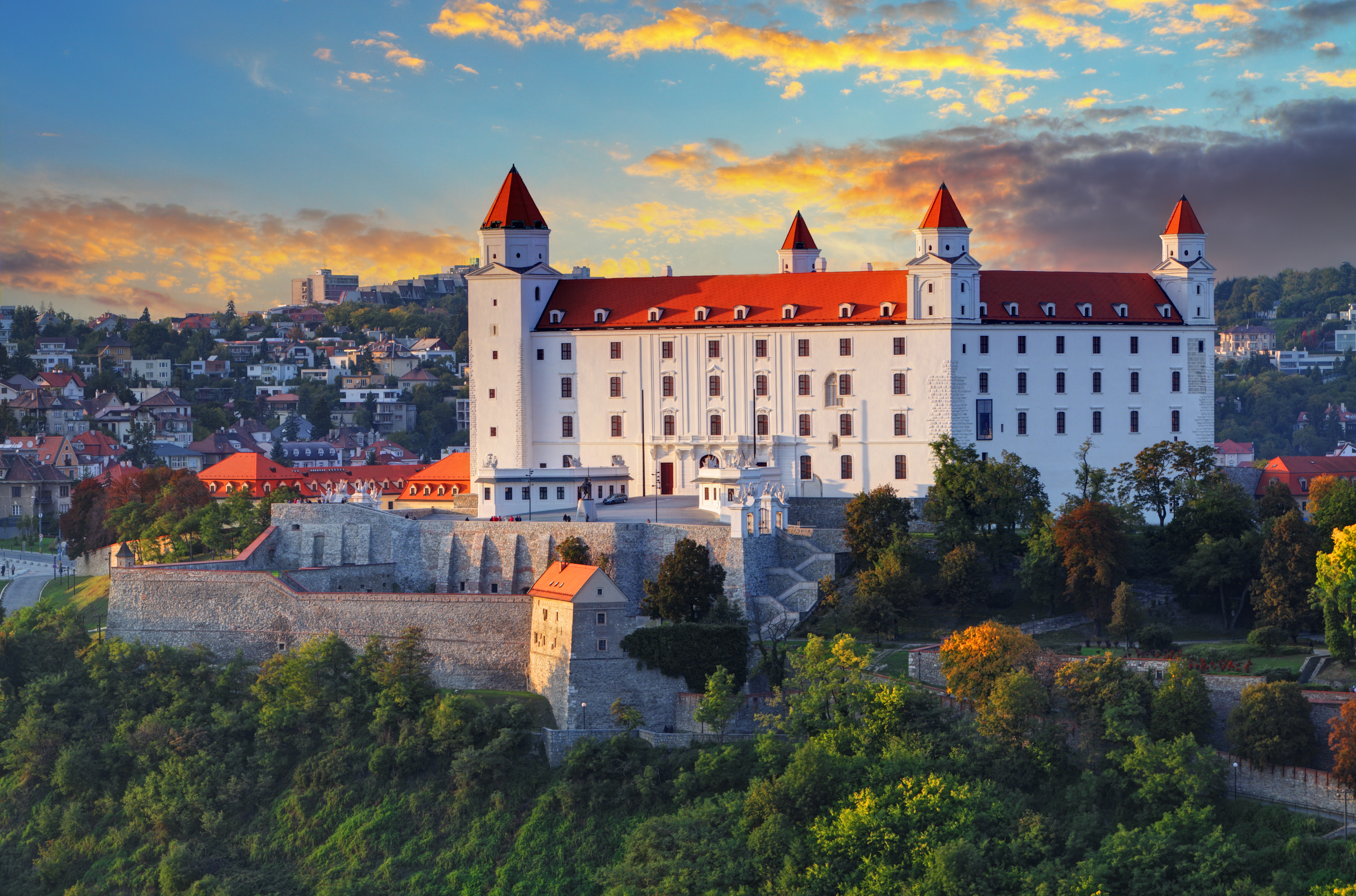 Spektakulær solnedgang bag det historiske Bratislava-slot, der troner på bakken over byen og Donau-floden i Slovakiet