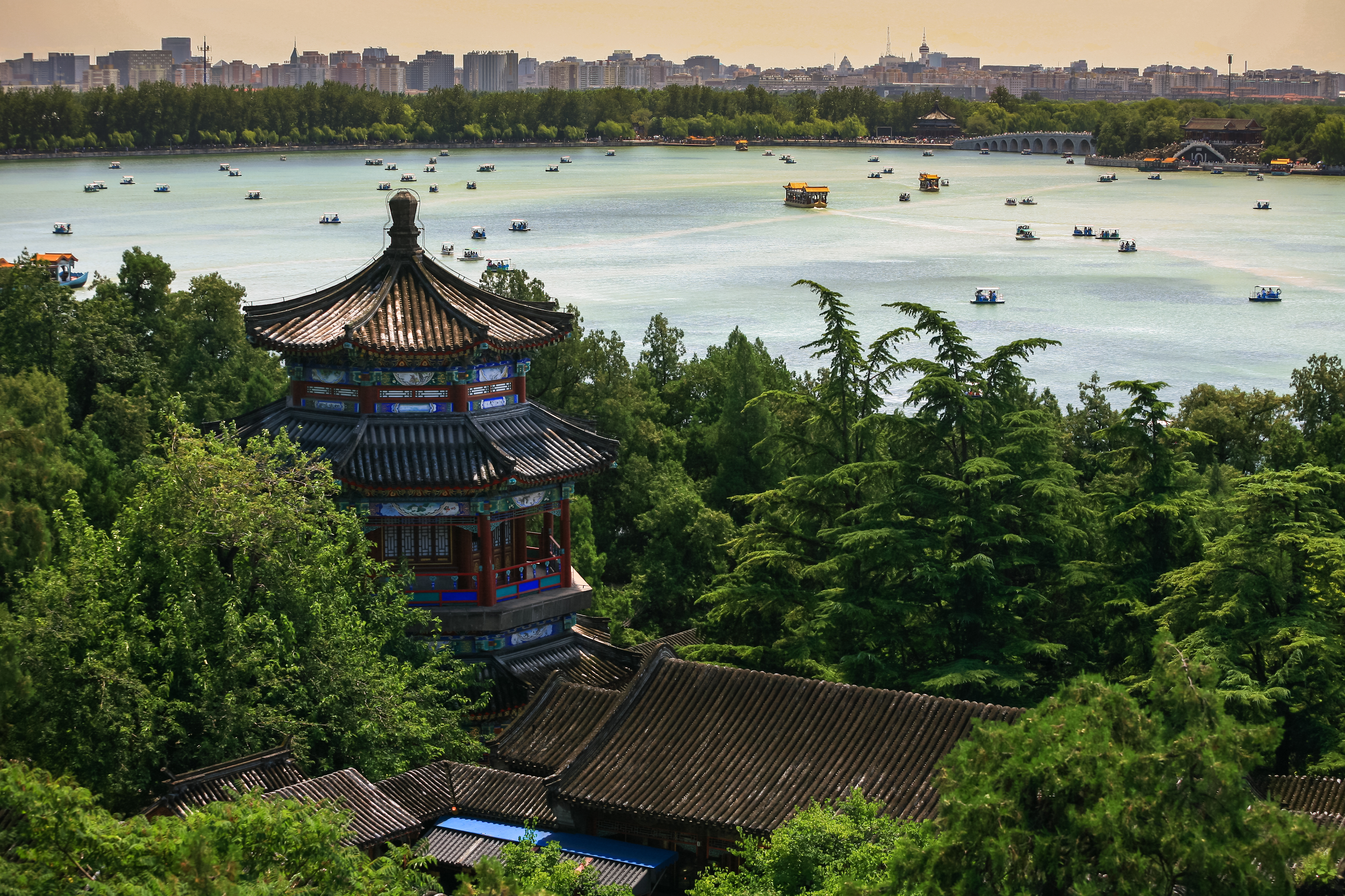Panoramaudsigt fra pagoda over idyllisk sø med lystbåde i Kinas Sommerpalads