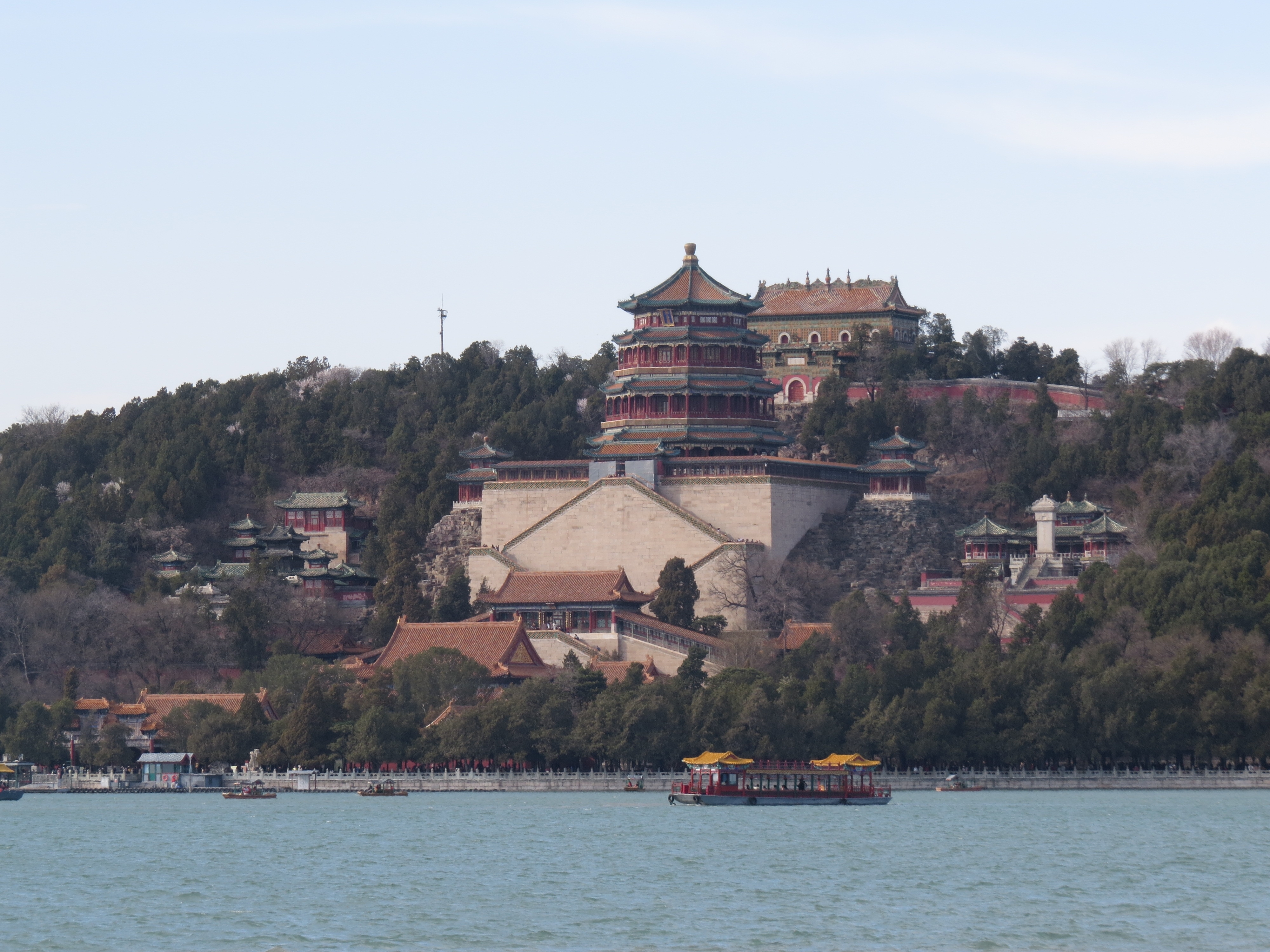 Sommerpaladsets imponerende arkitektur på Longevity Hill i Beijing, Kina, med udsigt over Kunming-søen og traditionelle kinesiske både