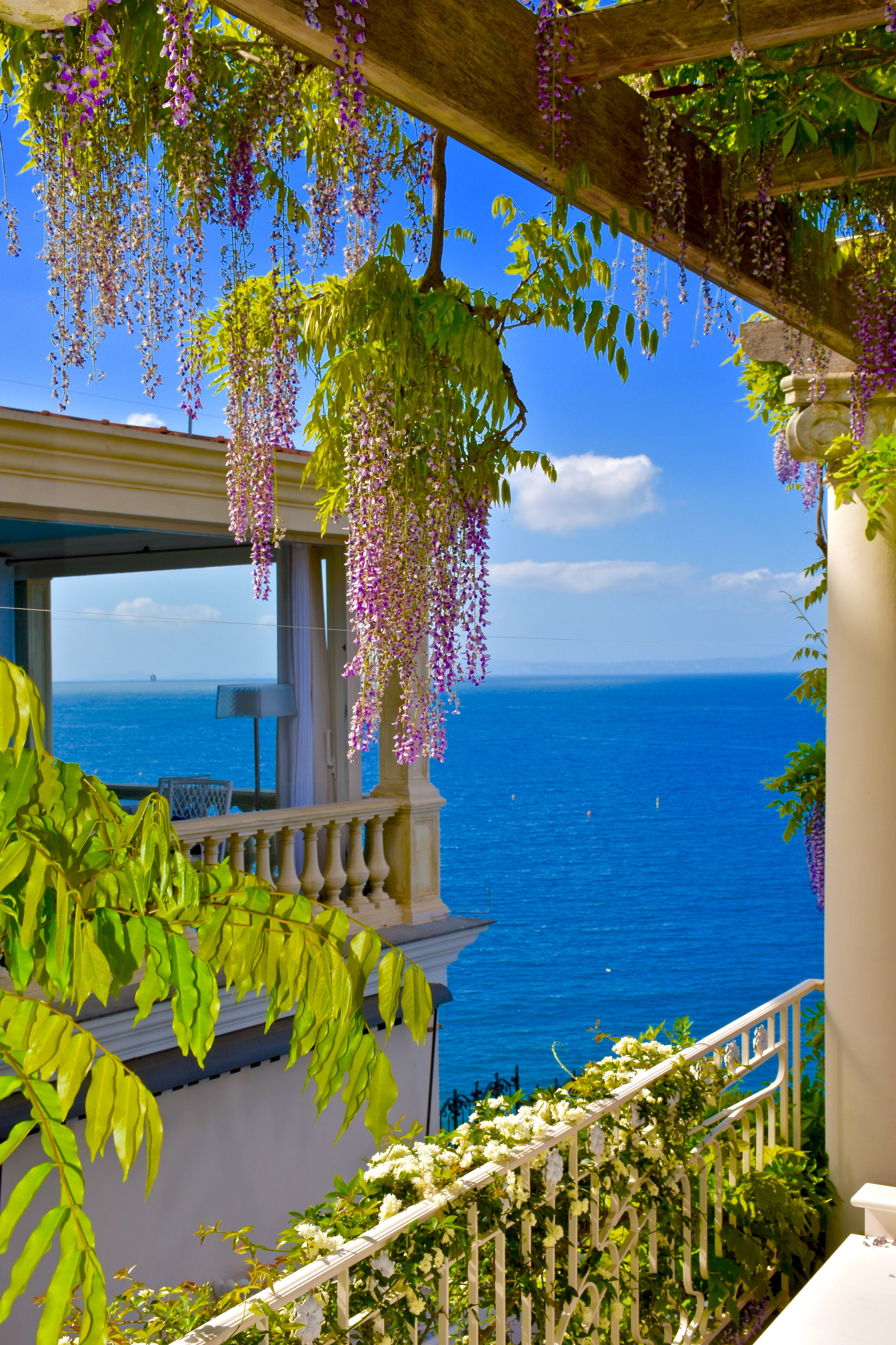Drømmeterrasse i Sorrento med lilla blomster og azurblåt middelhav