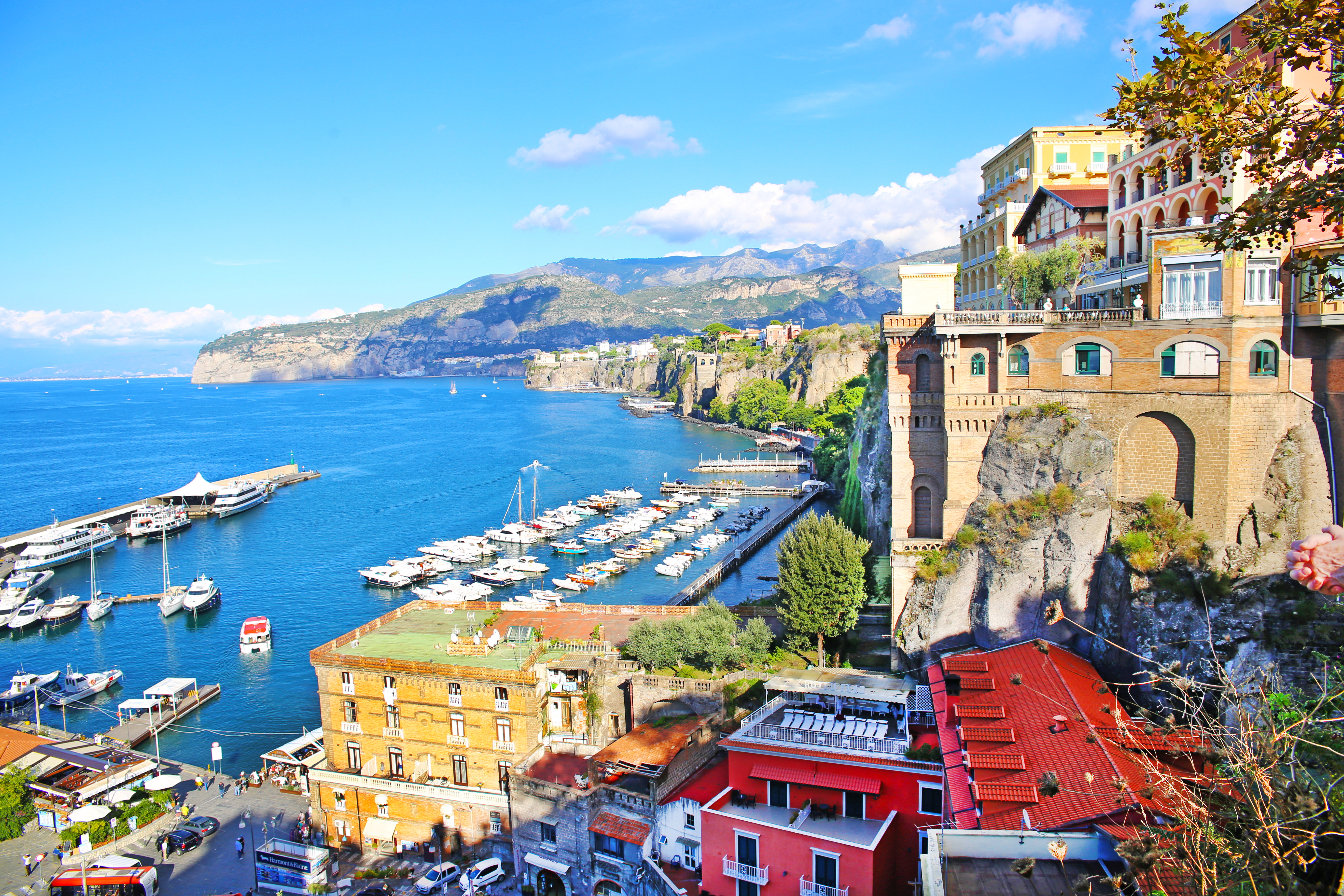 Idyllisk panorama over Sorrentos kystlinje med marinaen, farverige bygninger og Napoli-bugtens azurblå vand i Italien