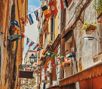 Malerisk smal gade med farverige flag og varme bygningsfacader i den gamle bydel af Sorrento, et perfekt eksempel på italiensk kystcharme