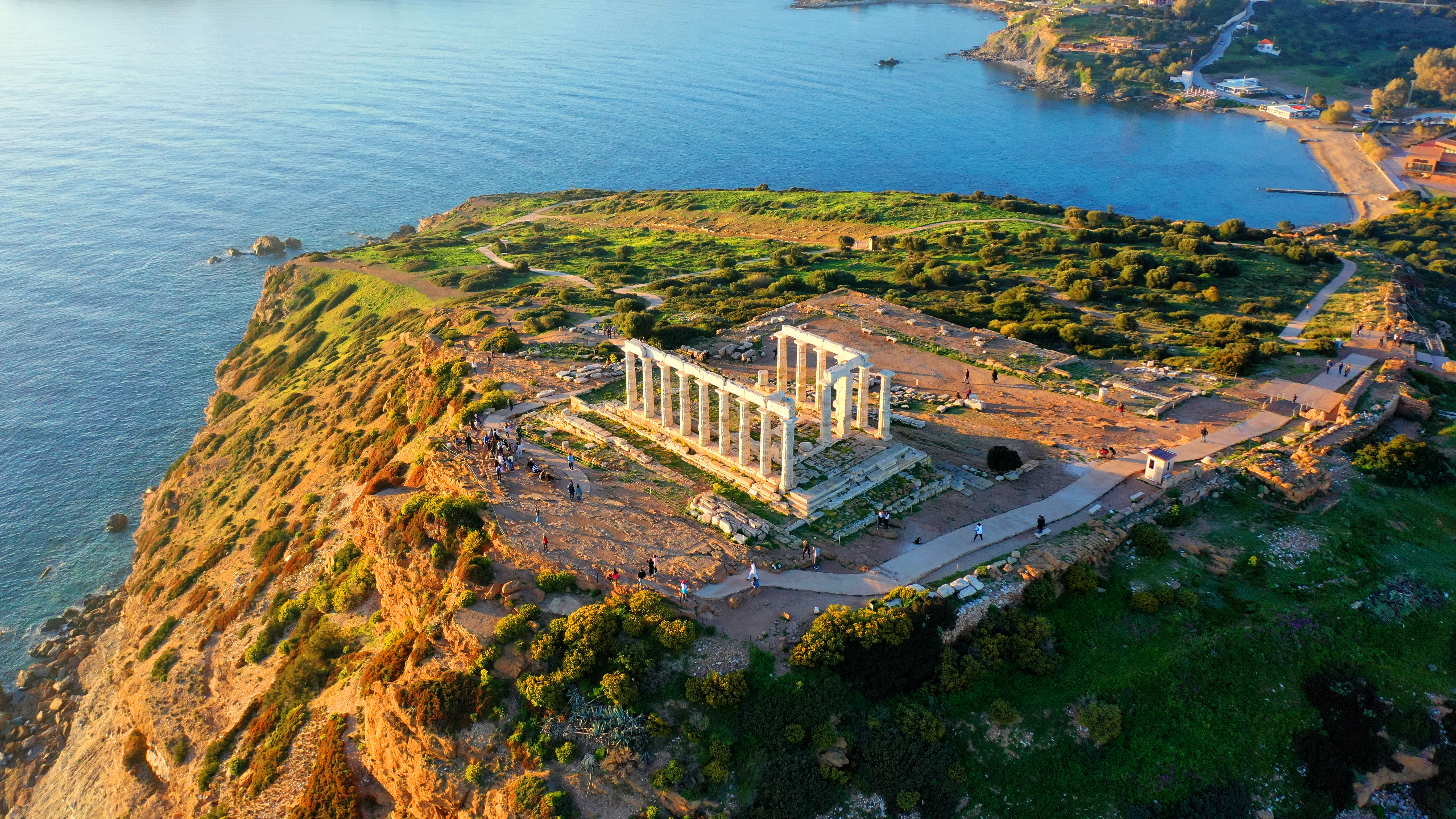 Majestætisk udsigt over det antikke Poseidon-tempel på Kap Sounion med de historiske søjler, der rejser sig på klippekysten med panoramaudsigt over det blå Ægæiske Hav